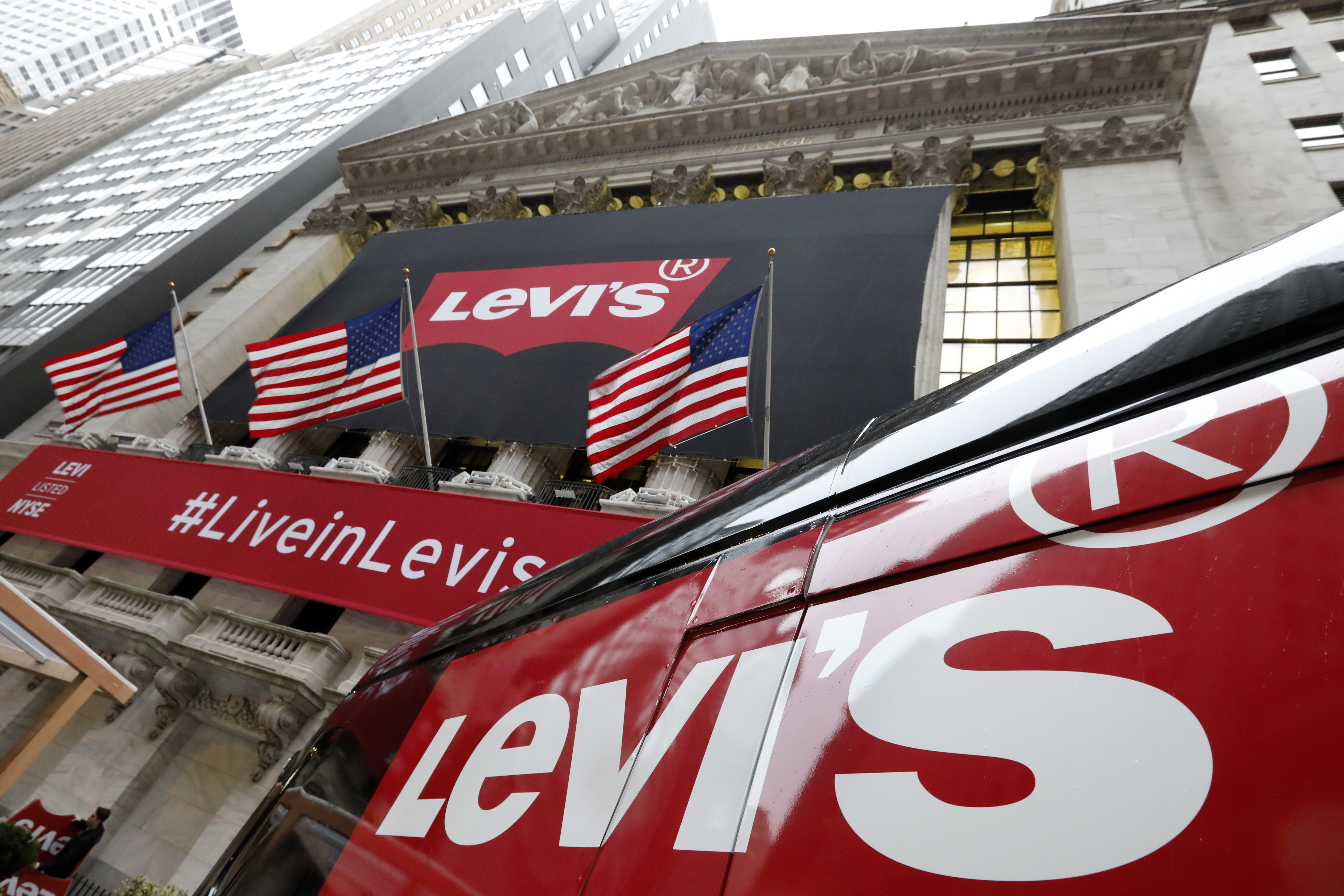 FILE - A Levi's banner adorns the facade of the New York Stock Exchange, March 21, 2019. Denim giant Levi Strauss & Co. said Thursday, Jan. 25, 2024, that it's slashing its global corporate workforce by 10% to 15% in the first half of the year as part of a two-year restructuring plan that seeks to simplify its operations. 