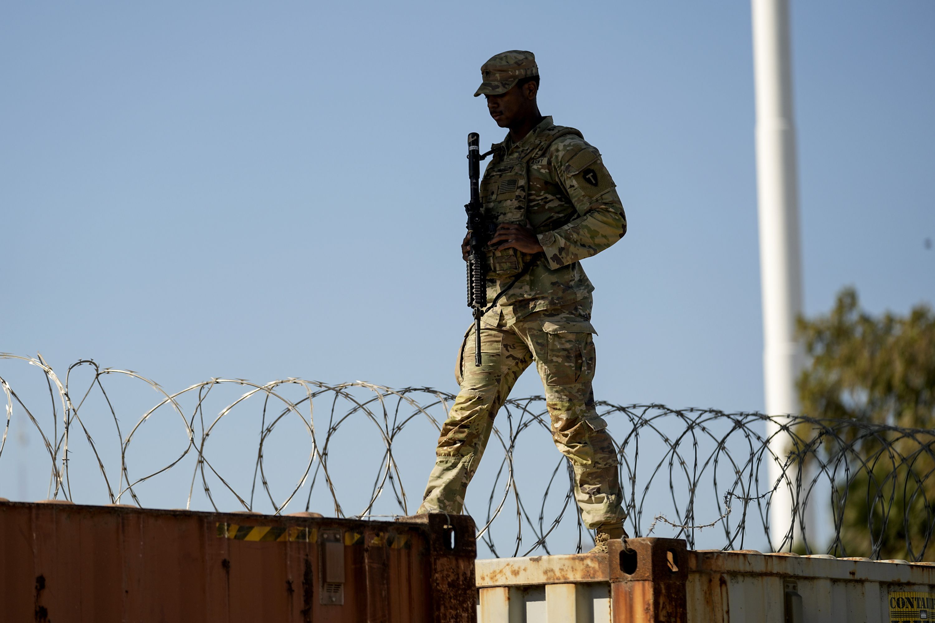 A guardsman walks over rail cars with Concertina wire along the Texas-Mexico border, Jan. 3, in Eagle Pass, Texas. Democratic and Republican lawmakers have struggled to reach an agreement on what to do about border security.