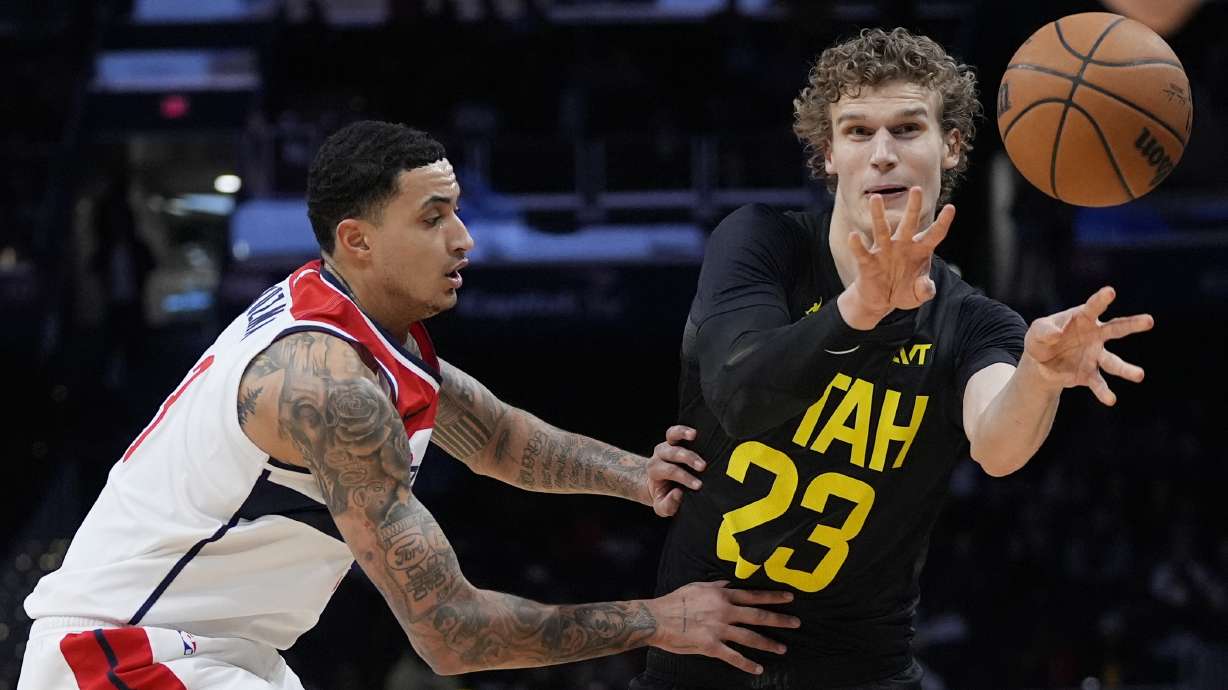 Utah Jazz forward Lauri Markkanen (23) passes the ball around Washington Wizards forward Kyle Kuzma, left, during the first half of an NBA basketball game Thursday, Jan. 25, 2024, in Washington.