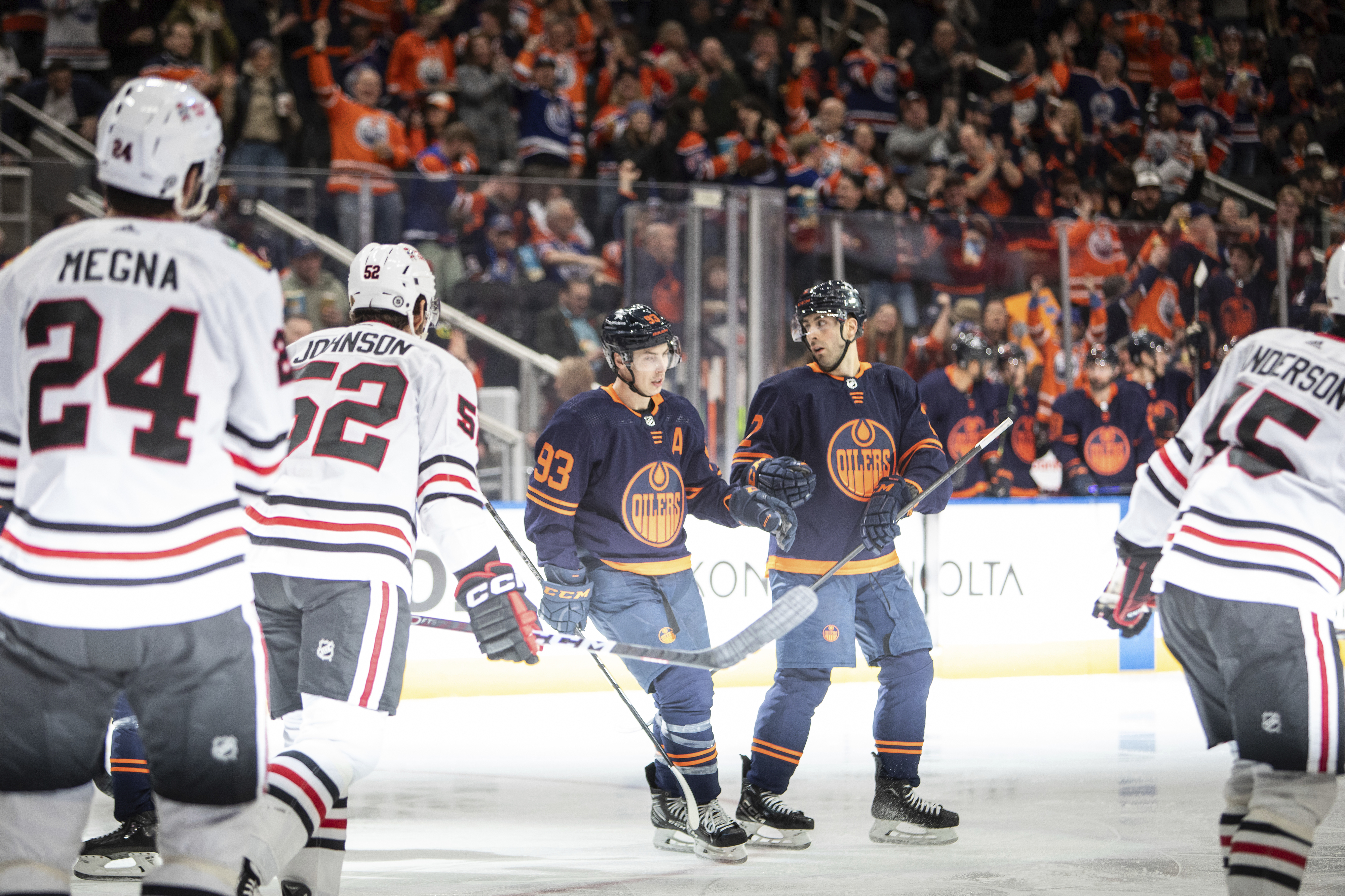 Edmonton Oilers' Ryan Nugent-Hopkins (93) and Evan Bouchard (2) celebrate an Oilers goal, while Chicago Blackhawks' Jaycob Megna (24), Reese Johnson (52) and Joey Anderson (15) skate away during the second period of an NHL hockey game Thursday, Jan. 25, 2024, in Edmonton, Alberta. 