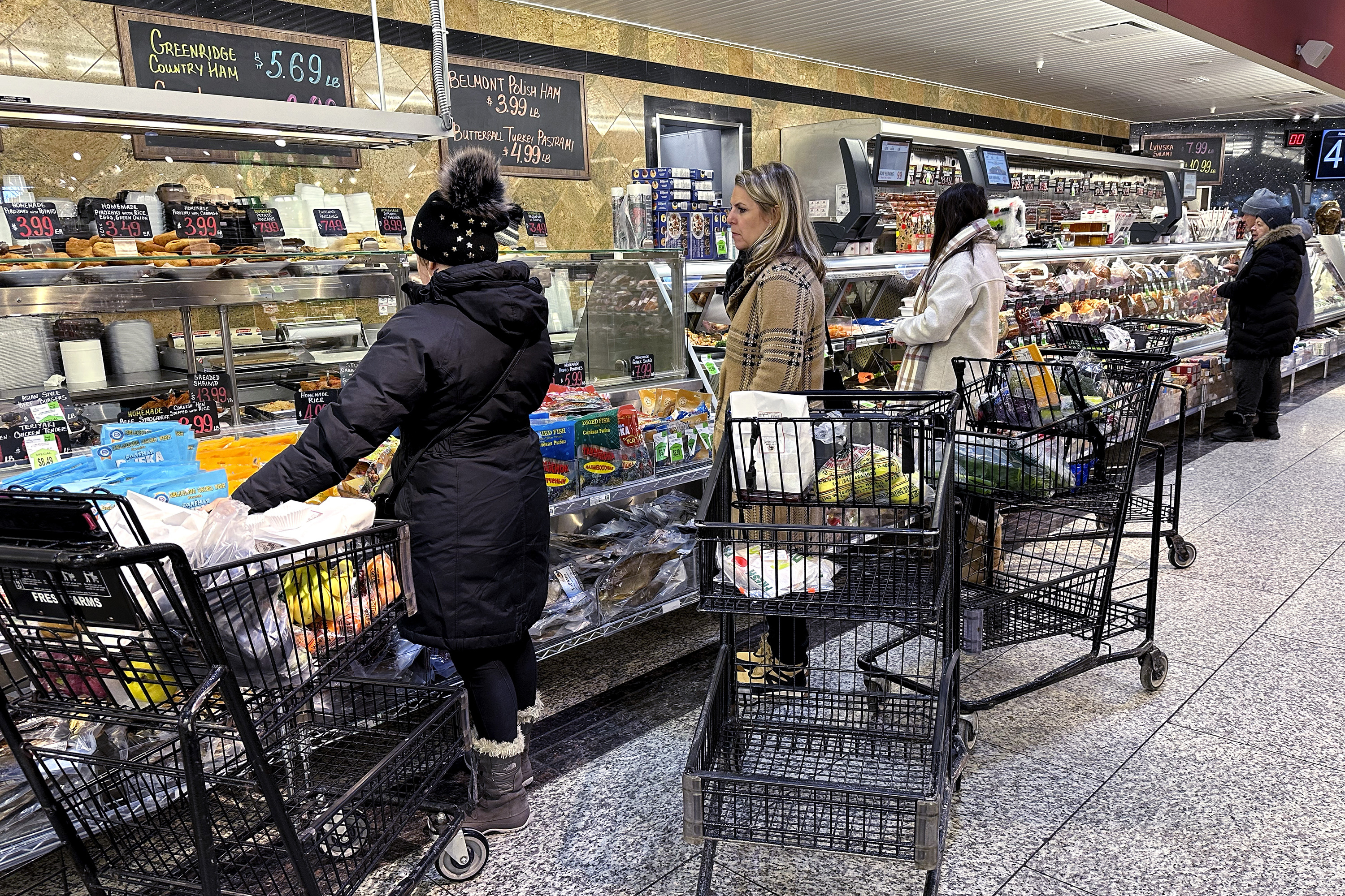 Customers wait for orders at a grocery store in Wheeling, Ill., Jan. 19. On Friday, the Commerce Department report showed that prices rose just 0.2% from November to December.