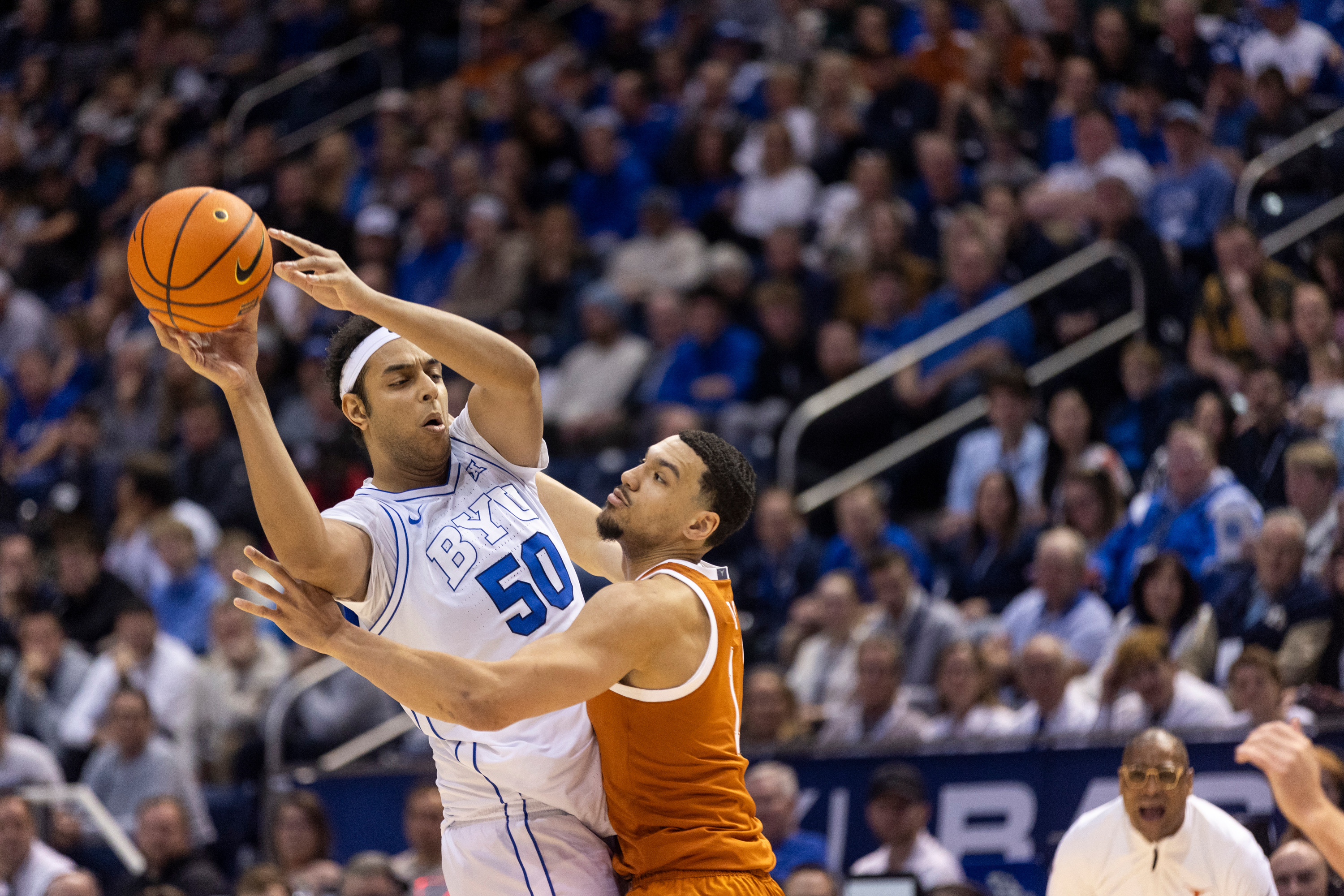 BYU center Aly Khalifa (50) passes the ball while blocked by Texas forward Dylan Disu (1) during their game in Provo on Saturday, Jan. 27, 2024.