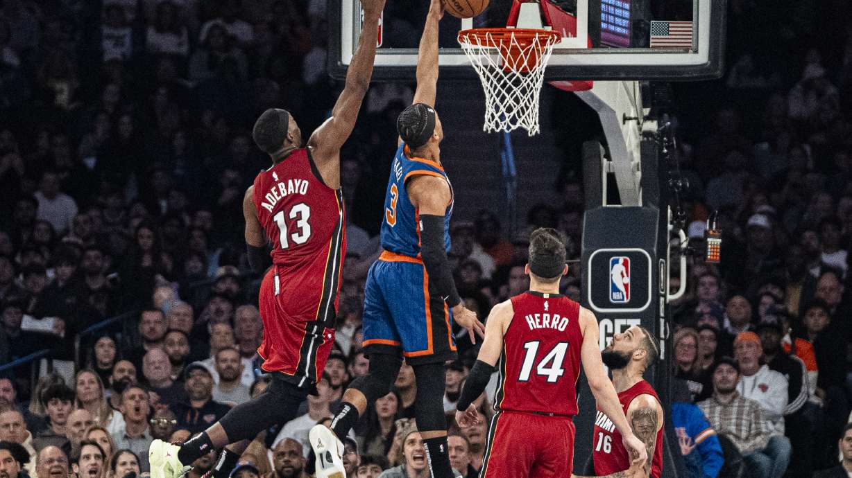 New York Knicks guard Josh Hart (3) dunks ahead of Miami Heat center Bam Adebayo (13) during the first half of an NBA basketball game on Saturday, Jan. 27, 2024, in New York.