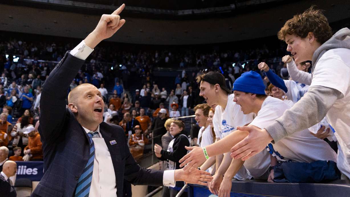 BYU head coach Mark Pope high fives fans after their win against Texas in Provo on Saturday, Jan. 27, 2024. BYU won 84-72.