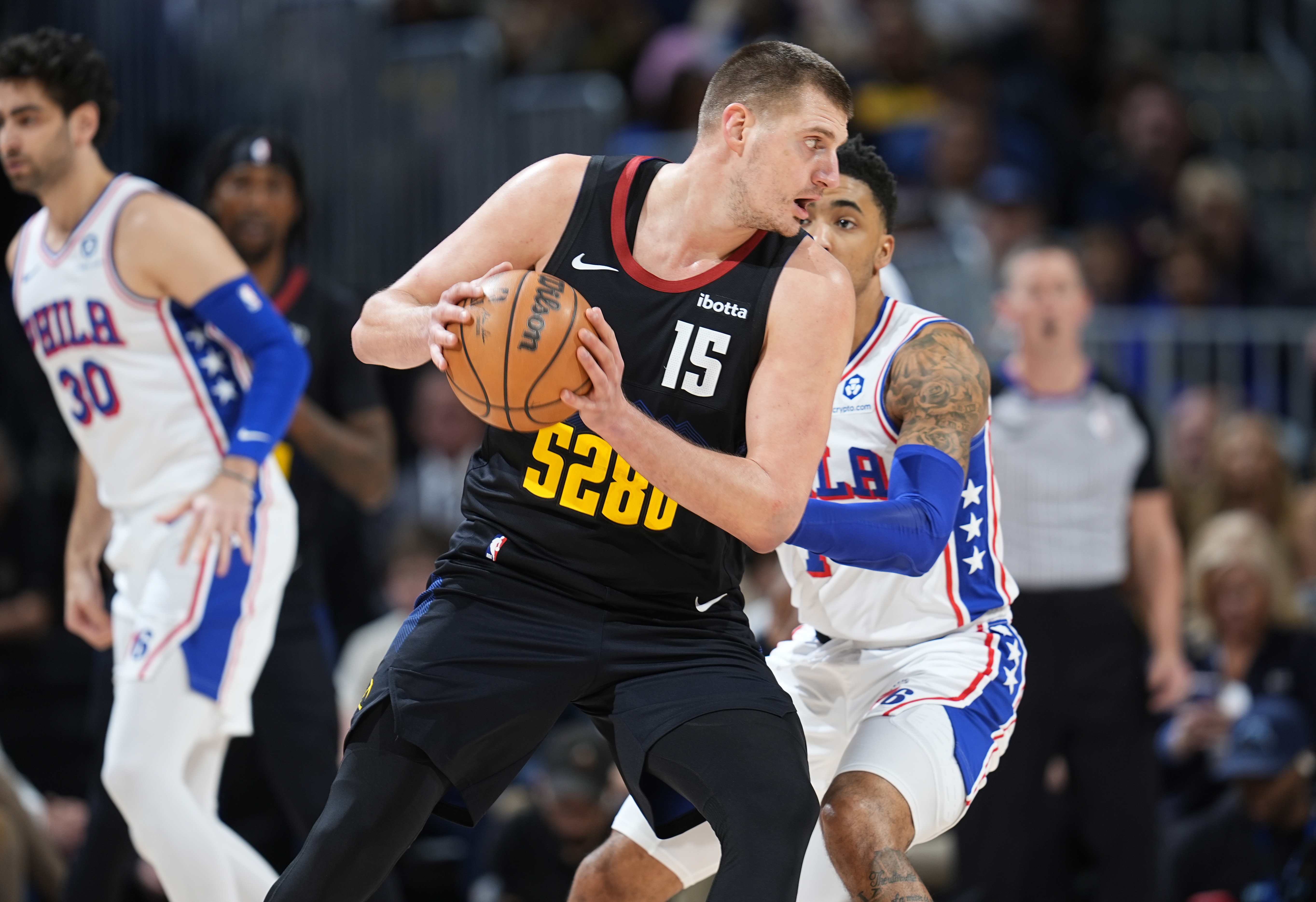 Denver Nuggets center Nikola Jokic, front, looks to pass the ball as Philadelphia 76ers forward KJ Martin defends in the first half of an NBA basketball game, Saturday, Jan. 27, 2024, in Denver. 