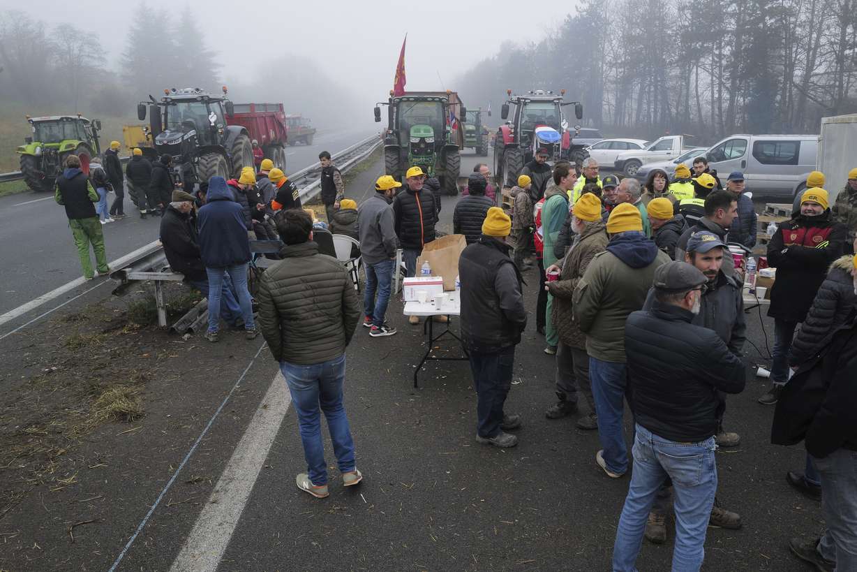 Farmers block a highway, near Agen, southwestern France, Saturday. French farmers have vowed to continue protesting and are maintaining traffic barricades on some of the country's major roads. The government announced a series of measures Friday, but the farmers say these do not fully address their demands.