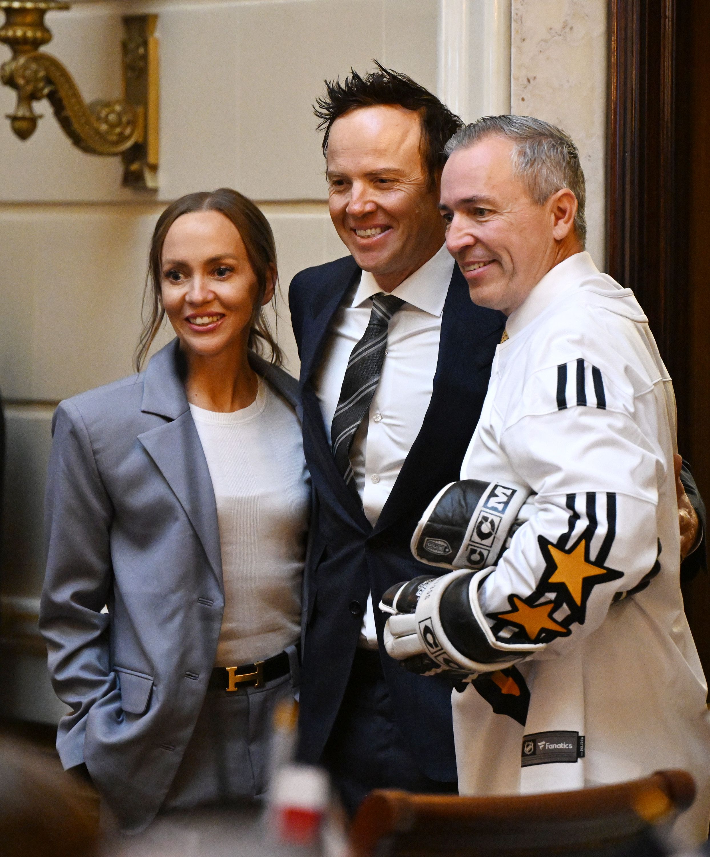 Utah Jazz owner Ryan Smith and his wife Ashley Smith pose for photos with Sen. Daniel McCay, R-Riverton, in the Senate as the SJR12 resolution on bringing an NHL hockey franchise to Utah is voted on at the Capitol in Salt Lake City on Monday.