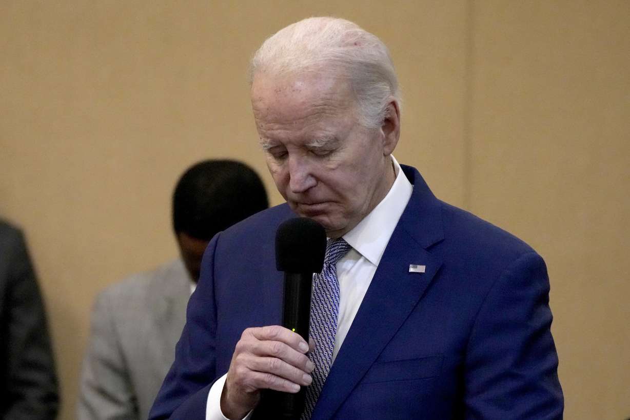 President Joe Biden bows his head in a moment of silence for the three American troops killed Sunday in a drone strike in northeast Jordan, while speaking at a Baptist church's banquet hall in West Columbia, S.C.