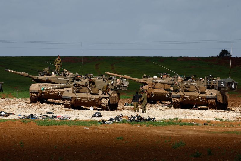 Israeli soldiers work by their tanks, amid the ongoing conflict between Israel and the Palestinian Islamist group Hamas, near the northern Gaza border in Israel, Tuesday.