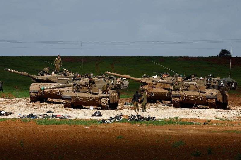 Israeli soldiers work by their tanks, amid the ongoing conflict between Israel and the Palestinian Islamist group Hamas, near the northern Gaza border in Israel, Tuesday.