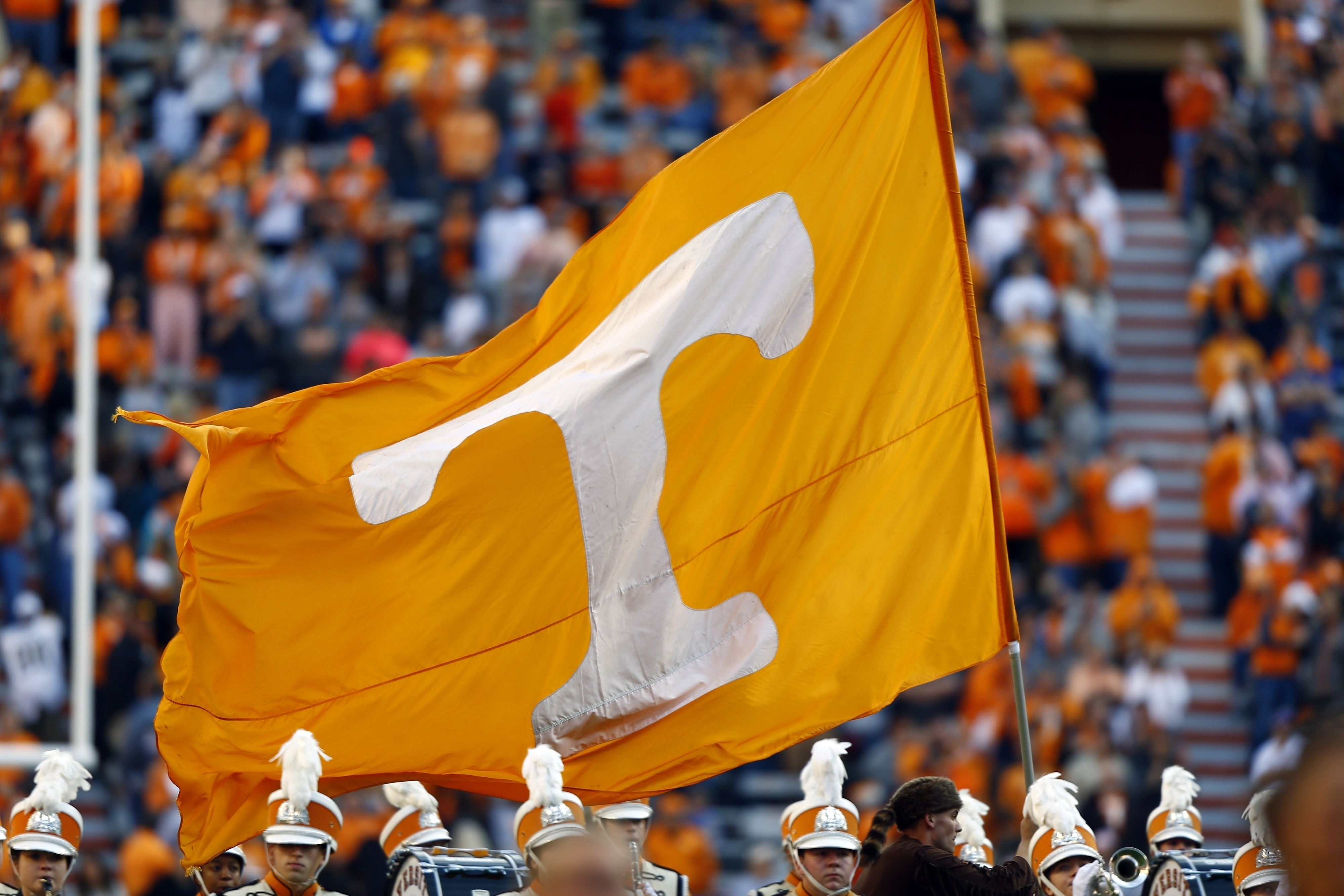 FILE - A Tennessee cheerleader runs with a flag before an NCAA college football game against Vanderbilt Saturday, Nov. 25, 2017, in Knoxville, Tenn. Tennessee has been in contact with NCAA investigators and a person with direct knowledge of the situation told The Associated Press on Tuesday, Jan. 30, 2024, the inquiry is into potential rules violations related to name, image and likeness compensation for multiple athletes.