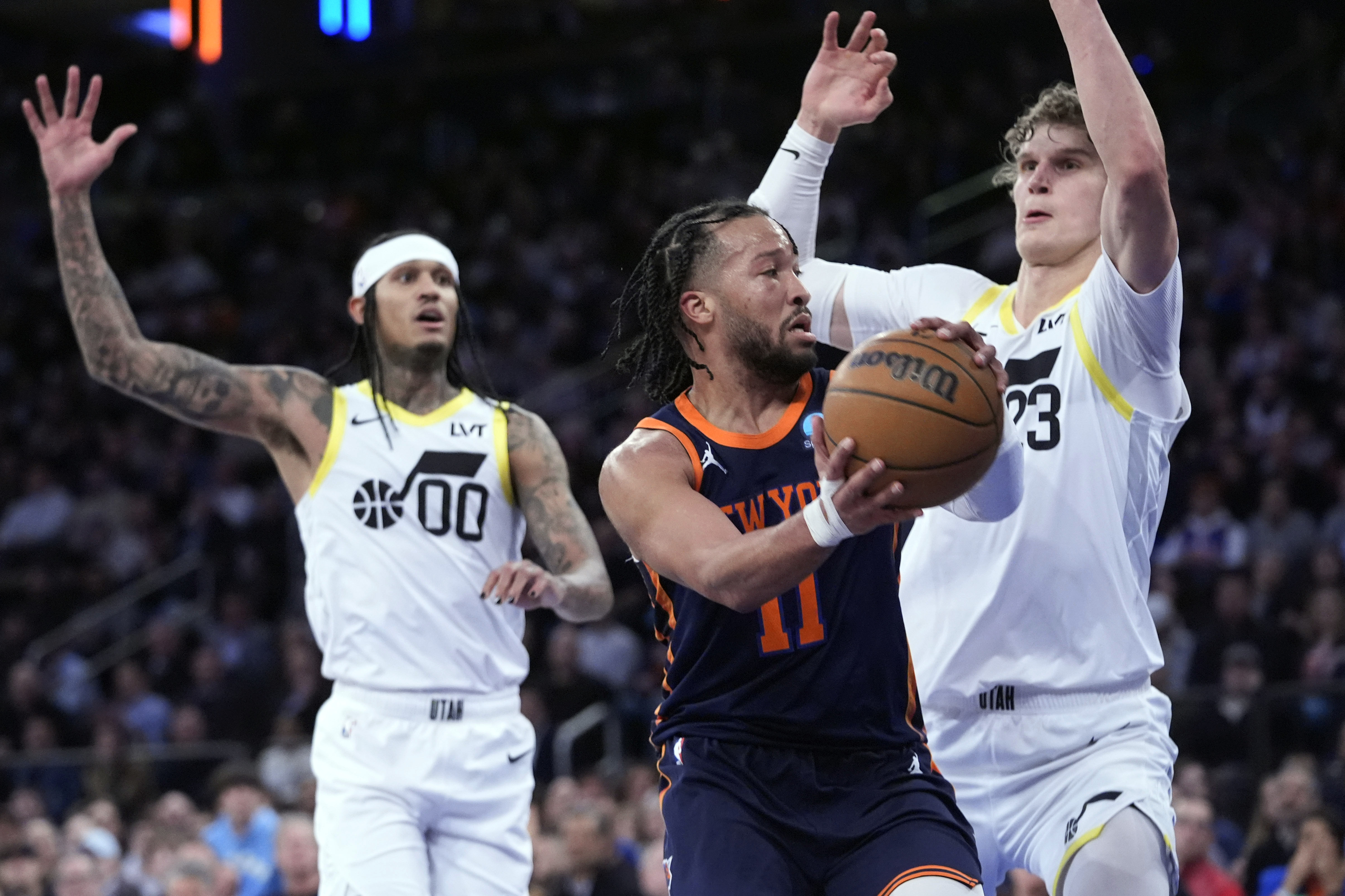 New York Knicks guard Jalen Brunson (11) looks to move the ball around Utah Jazz forward Lauri Markkanen (23) during the first half of an NBA basketball game, Tuesday, Jan. 30, 2024, at Madison Square Garden in New York.