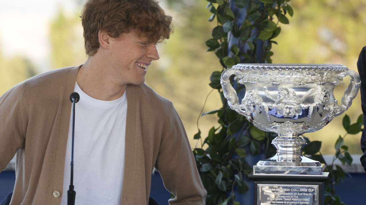 Italian tennis player Jannik Sinner looks at the Australian Open trophy he won on Sunday during a press conference in Rome, Wednesday, Jan. 31, 2024. Sinner, 22, was the the first Italian to win the Australian Open that is the first grand slam title of his career.