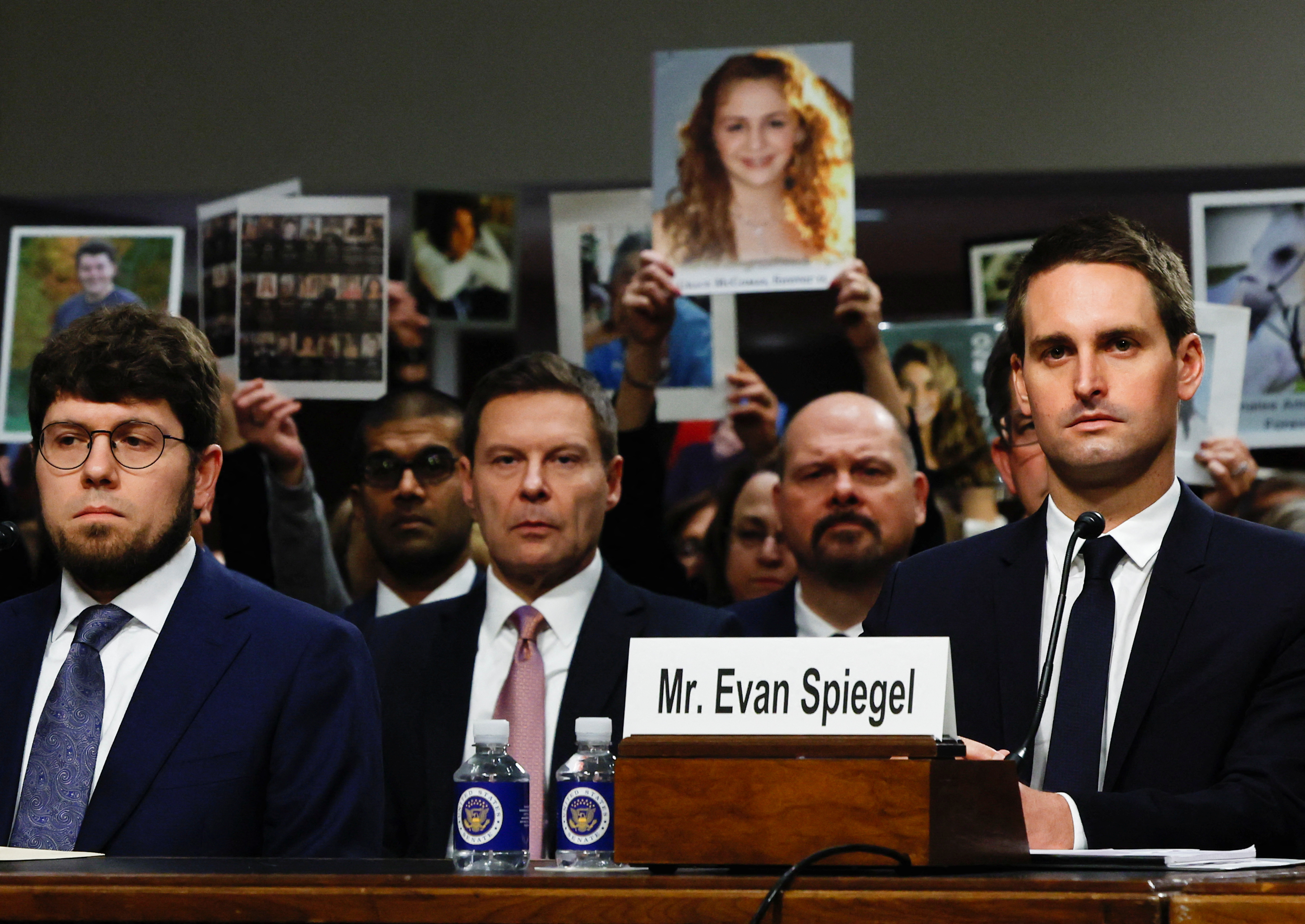 People hold placards as co-founder and CEO of Snap. Evan Spiegel attends a Senate Judiciary Committee hearing on online child sexual exploitation at the U.S. Capitol in Washington, Wednesday.