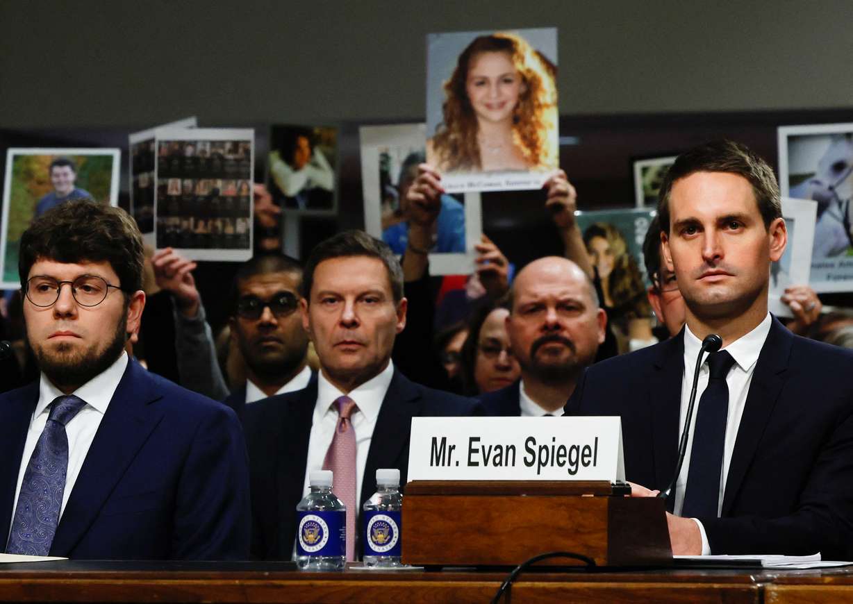 People hold placards as co-founder and CEO of Snap. Evan Spiegel attends a Senate Judiciary Committee hearing on online child sexual exploitation at the U.S. Capitol in Washington, Wednesday.