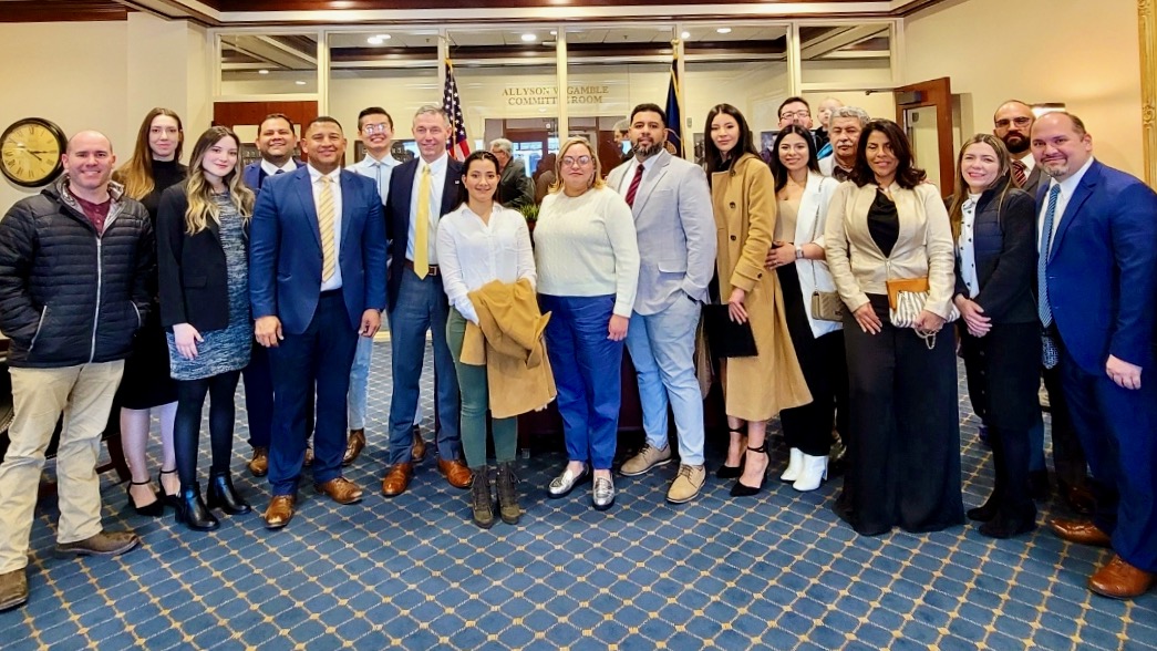 A contingent of immigrants, shown at the state Capitol on Jan. 26, is pushing an anti-communist message bill. Sen. Michael Kennedy, SJR5 sponsor, is left of center in the photo in a yellow tie. Carlos Moreno is left of Kennedy, also wearing a yellow tie.