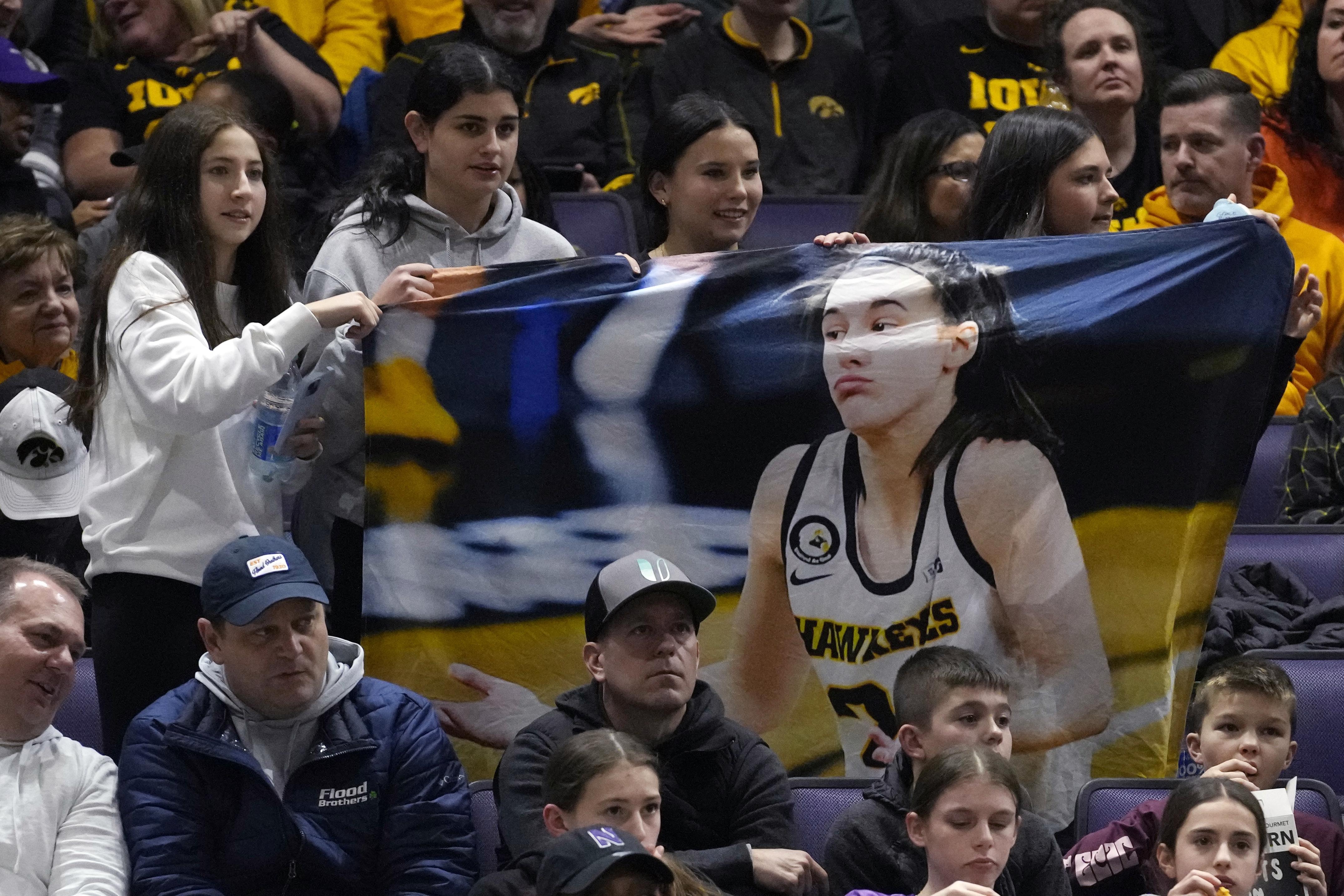 Supporters cheer for Iowa guard Caitlin Clark before an NCAA college basketball game between Iowa and Northwestern in Evanston, Ill., Wednesday, Jan. 31, 2024.