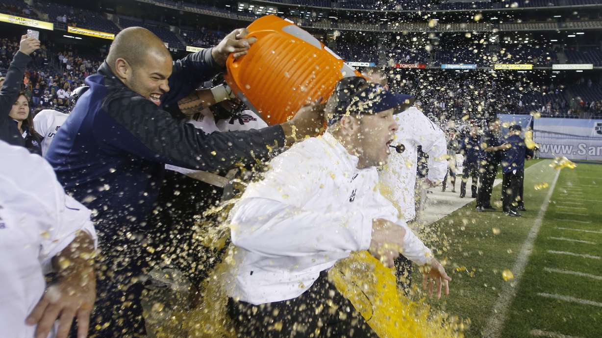 Former Utah State offensive linesman Kevin Whimpey dumps Gatorade on head coach Matt Wells in San Diego, Dec. 26, 2013. Whimpey was arrested Tuesday and accused of driving onto the USU football field while impaired.