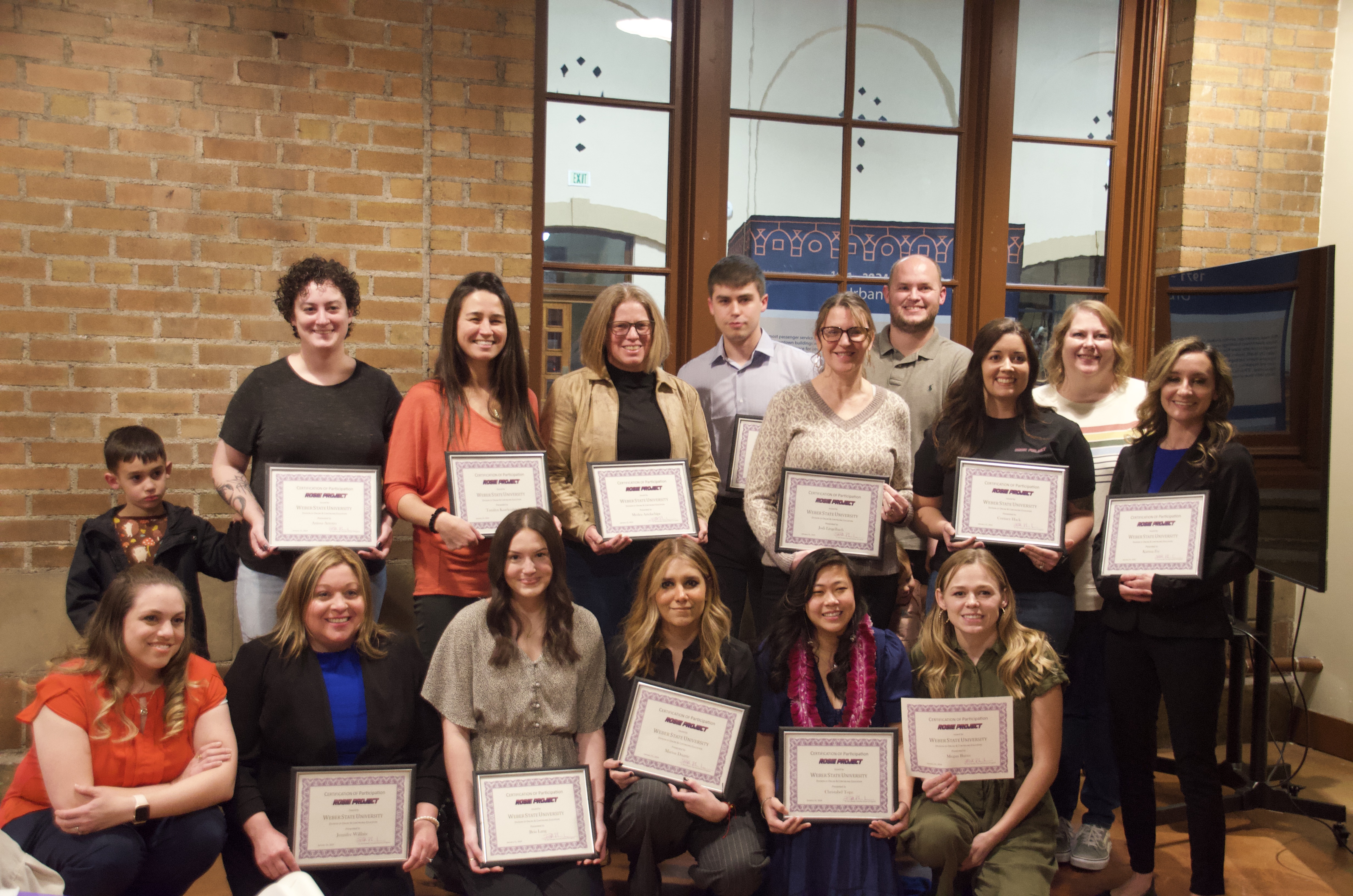 Graduates of the Rosie Project's second graduating cohort pose with their certificates at the graduation ceremony.