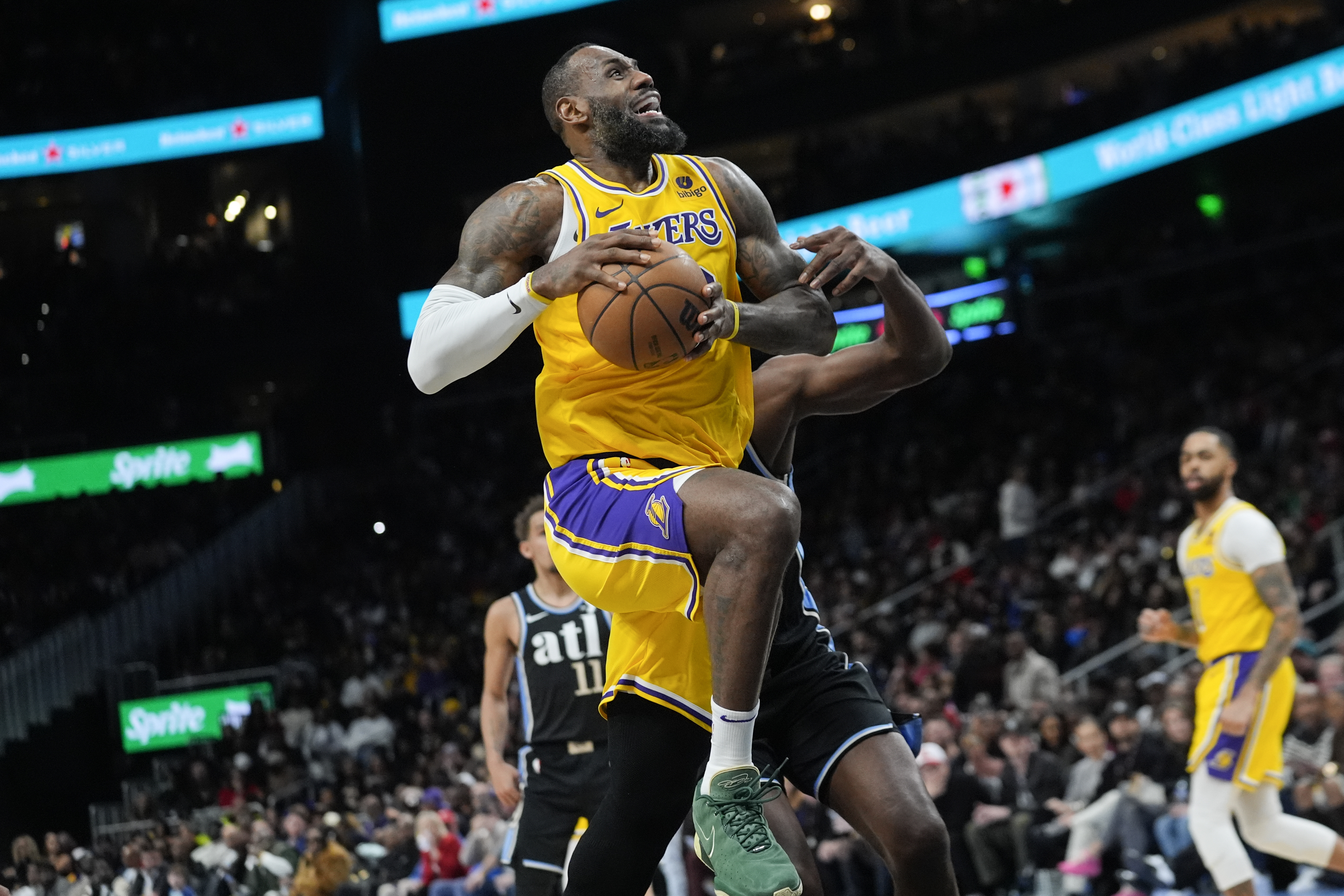 Los Angeles Lakers forward LeBron James (23) goes past Atlanta Hawks center Clint Capela (15) as he scores a basket in the second half of an NBA basketball game Tuesday, Jan. 30, 2024, in Atlanta. 