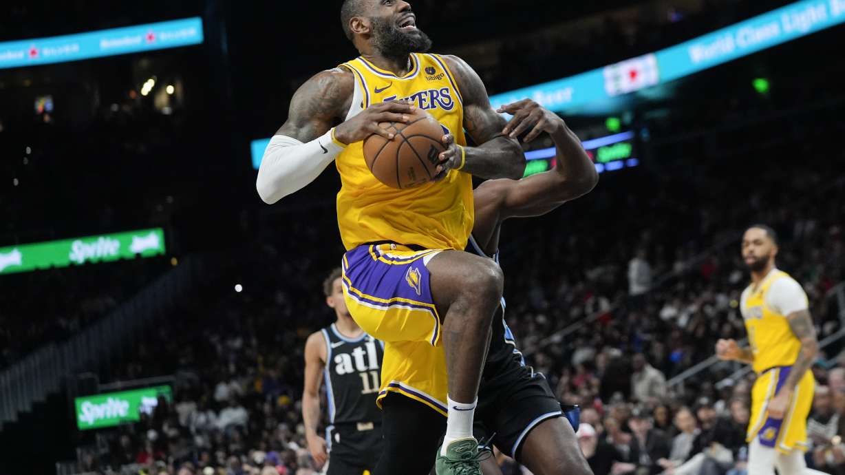 Los Angeles Lakers forward LeBron James (23) goes past Atlanta Hawks center Clint Capela (15) as he scores a basket in the second half of an NBA basketball game Tuesday, Jan. 30, 2024, in Atlanta.