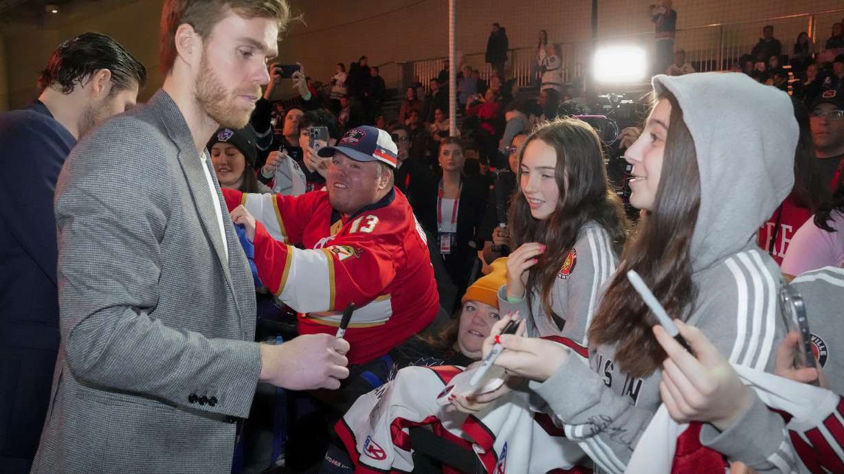 Edmonton Oilers captain Connor McDavid, left, signs autographs for fans during the NHL All-Star week hockey festivities in Toronto on Thursday, Feb. 1, 2024.
