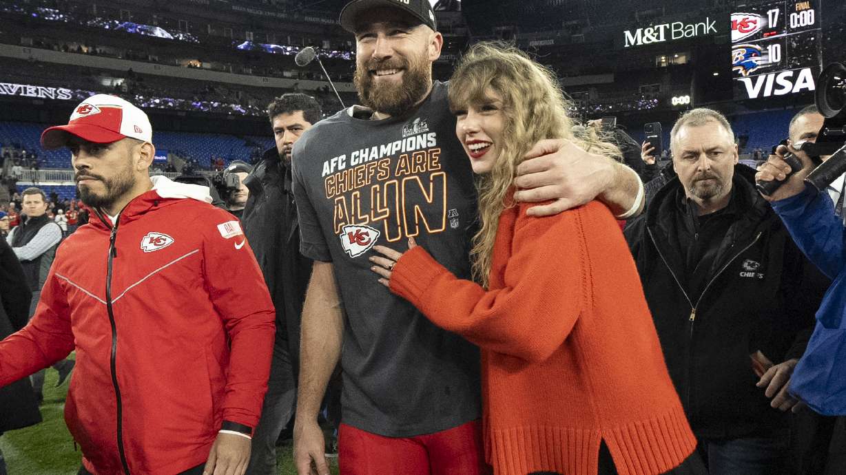 FILE - Kansas City Chiefs tight end Travis Kelce walks with Taylor Swift following the AFC Championship NFL football game between the Baltimore Ravens and the Kansas City Chiefs, Sunday, Jan. 28, 2024, in Baltimore. As the Kansas City Chiefs head to the Super Bowl, baseless conspiracy theories are spreading on social media suggesting that the romance between megastar Taylor Swift and Kansas City Chiefs tight end Travis Kelce is part of a secret plot to help President Joe Biden get reelected in 2024.