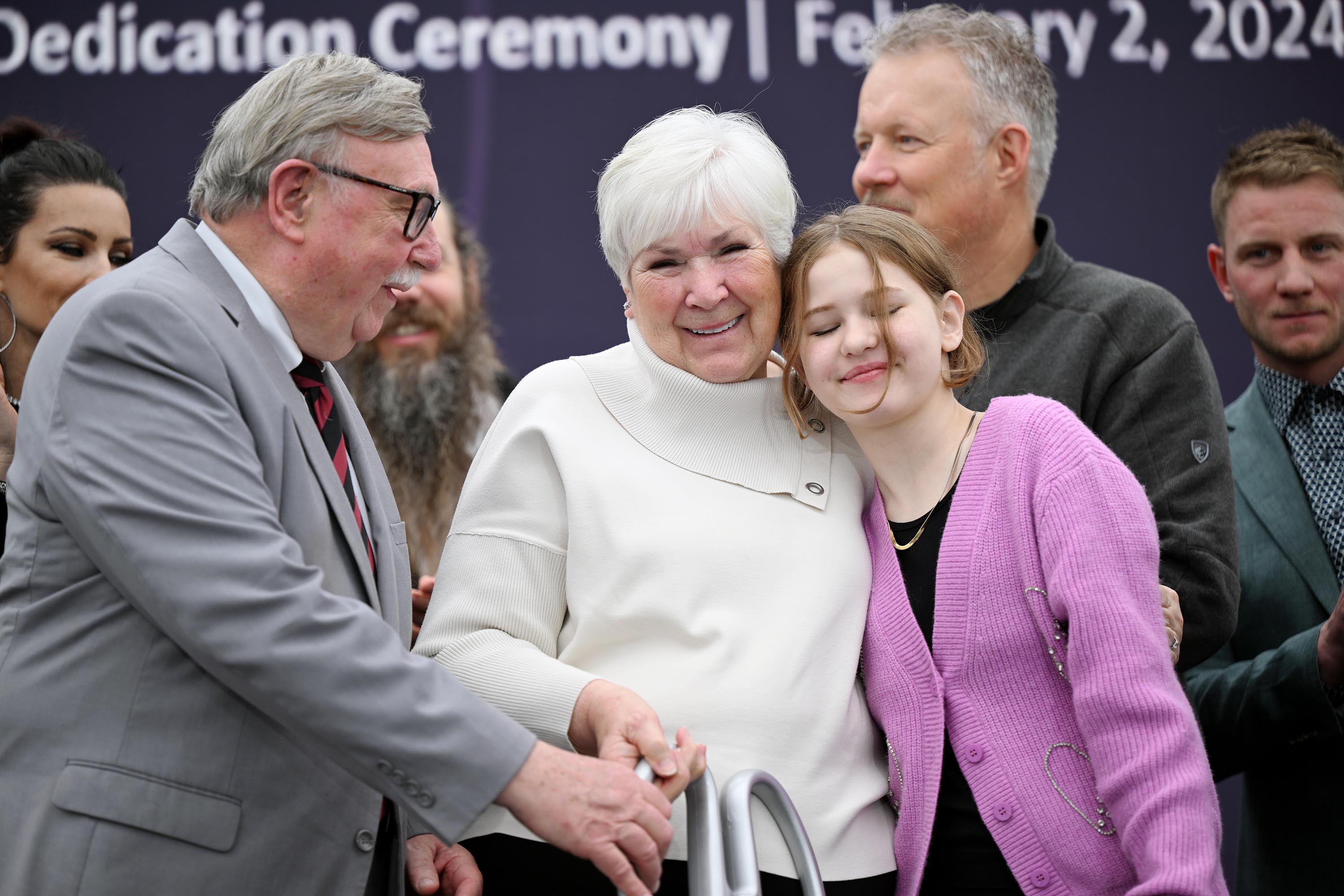 Kim Wilson helps his wife Gail Miller, with the scissors as she hugs Nellie Mainor, who spent three years on dialysis before receiving a kidney transplant, after they cut the ribbon at the new Intermountain Primary Children’s Hospital, Miller Family Campus, in Lehi on Friday.