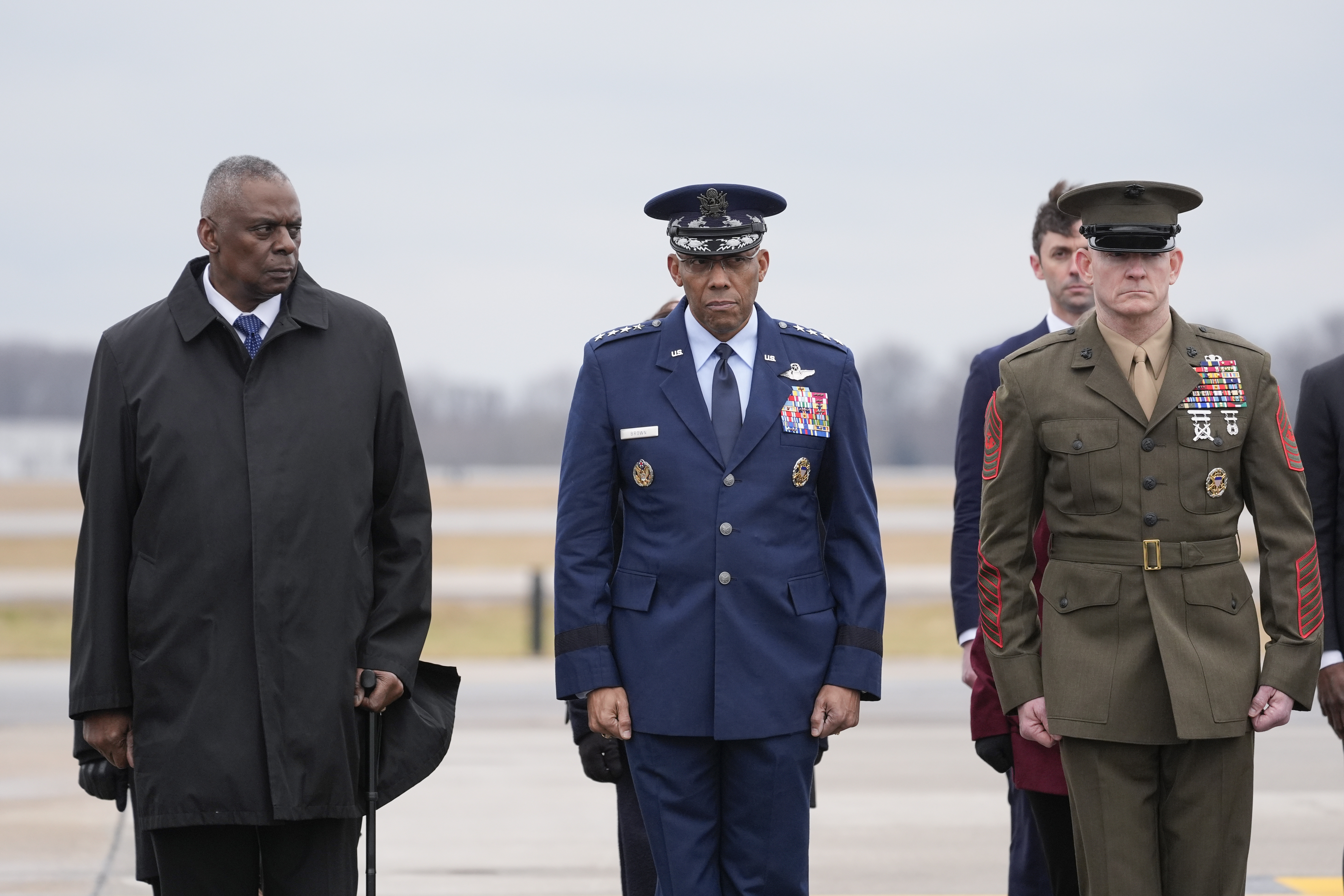Defense Secretary Lloyd Austin, Chairman of the Joint Chiefs of Staff Gen. CQ Brown and Marine Corp. Sgt. Maj. Troy E. Black watch as an Army carry team moves a flag-draped transfer case during a casualty return at Dover Air Force Base, Del., Friday.