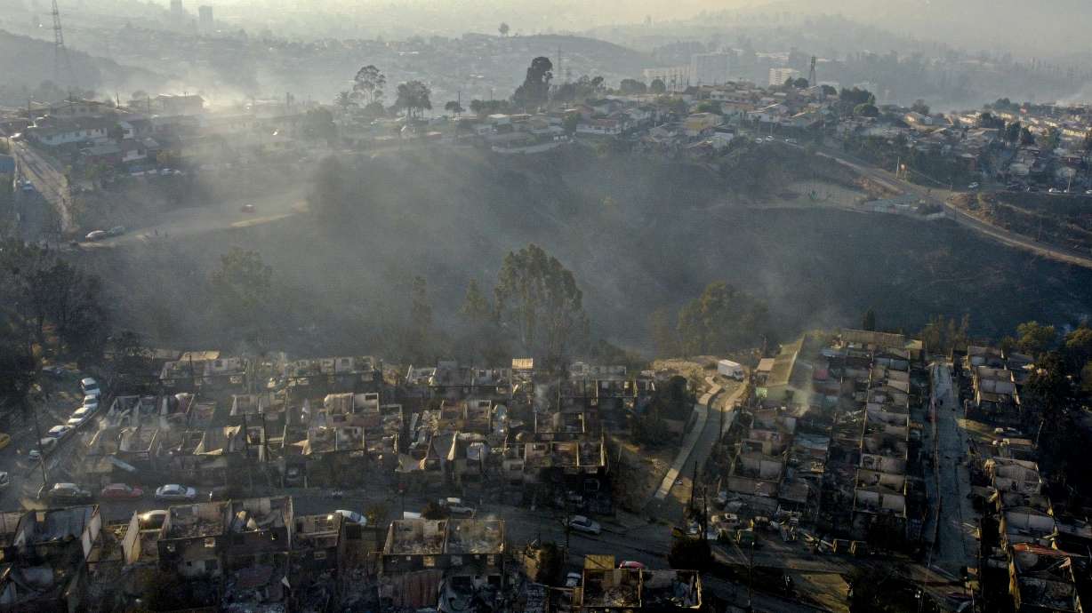 Smoke raises from burnt-out houses after a forest fire reached Villa Independencia neighborhood in Vina del Mar, Chile, on Feb. 3.