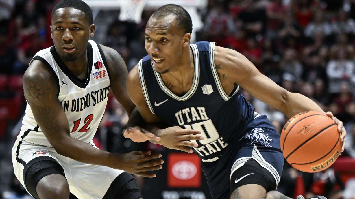 Utah State guard Darius Brown II (10) drives past San Diego State guard Darrion Trammell (12) during the first half of an NCAA college basketball game Saturday, Feb. 3, 2024, in San Diego.