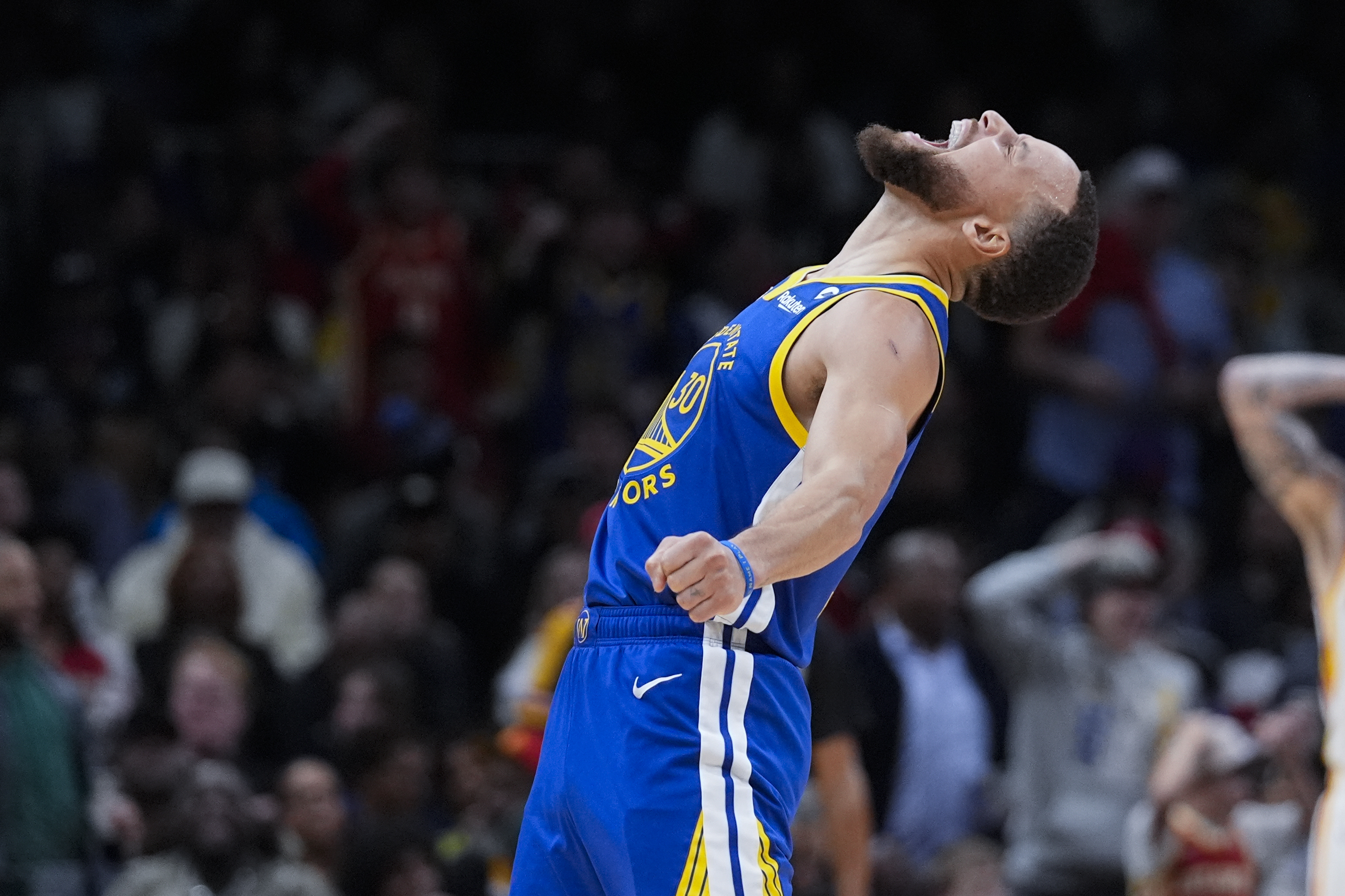 Golden State Warriors guard Stephen Curry reacts after scoring in the second half of an NBA basketball game against the Atlanta Hawks Saturday, Feb. 3, 2024, in Atlanta.