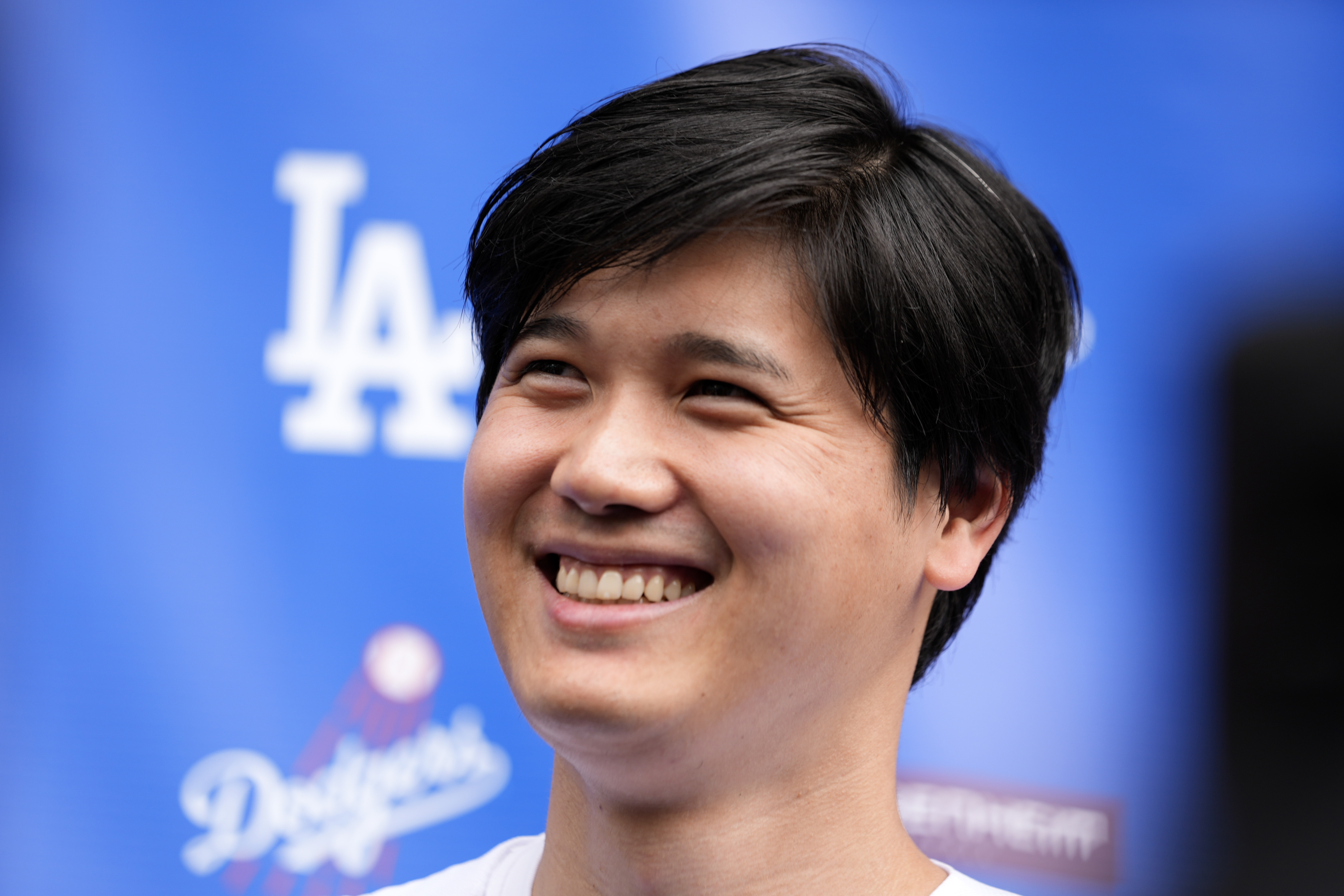 Los Angeles Dodgers' Shohei Ohtani smiles while talking to the media at Dodger Stadium during the DodgerFest baseball event Saturday, Feb. 3, 2024, in Los Angeles Calif. 