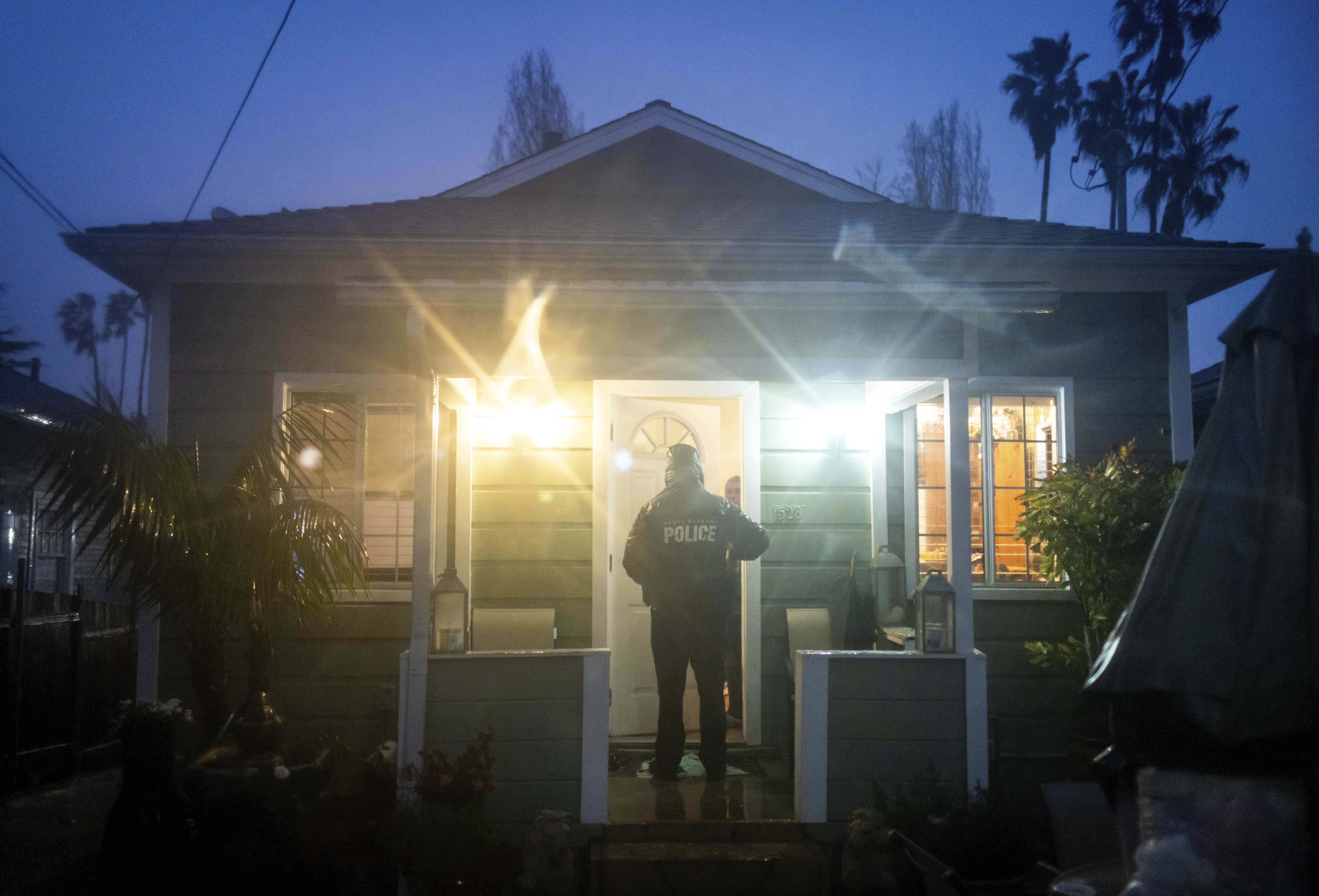 A police officer notifies a resident of rising floods during a rainstorm, Sunday, in Santa Barbara, Calif.