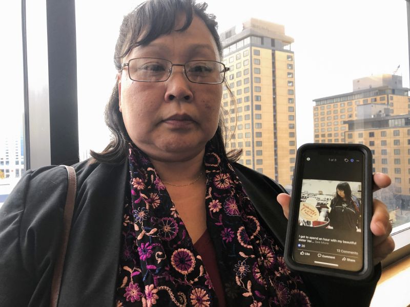 Rena Sapp, outside a courtroom Oct. 21, 2019, in Anchorage, Alaska, shows a photo of her sister, Veronica Abouchuk, taken during a day out shopping in 2013. Sapp attended the arraignment of Brian Steven Smith, who is accused of killing Abouchuk.