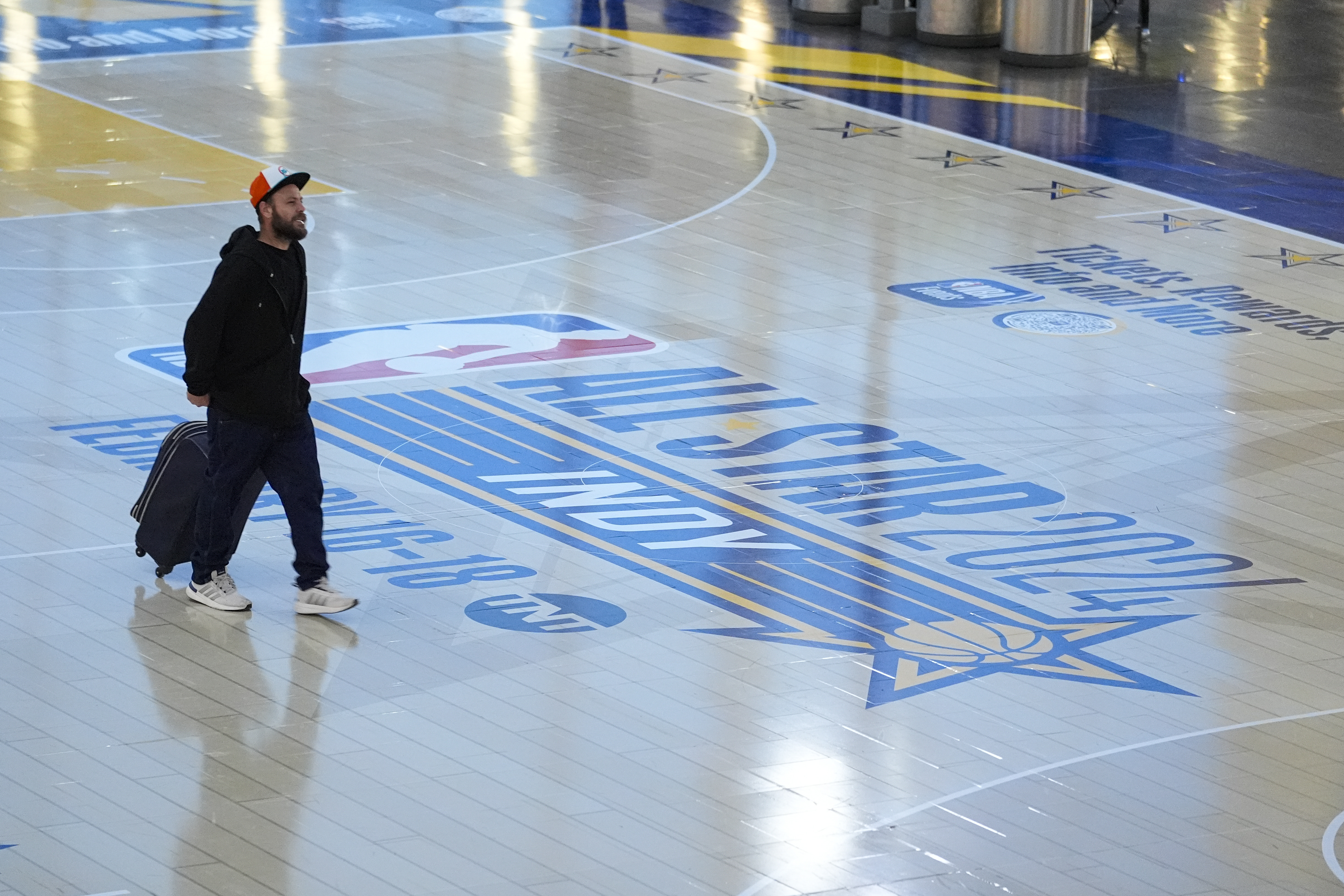 Travelers using Indianapolis International Airport make their way across a replica of the court that will be use for the NBA All-Star game Thursday, Jan. 18, 2024. Authorities have created a full-size replica basketball court with two baskets, one equipped with a short clock, to promote Indy's first All-Star Game since 1984. 