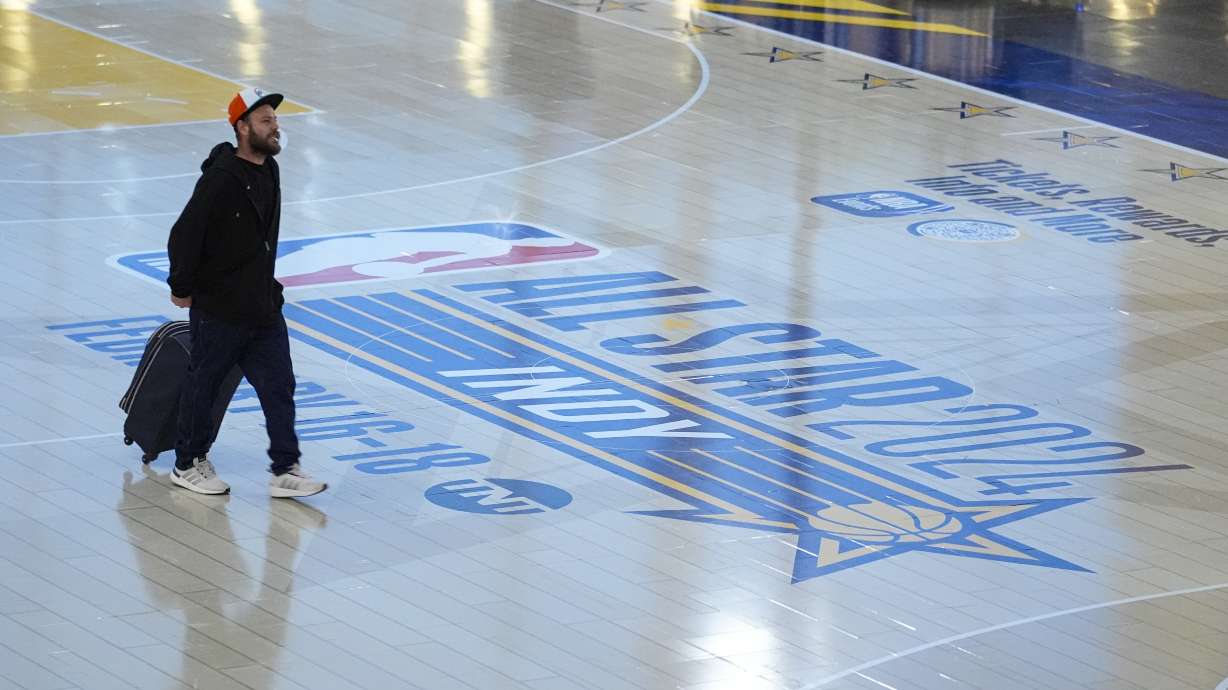 Travelers using Indianapolis International Airport make their way across a replica of the court that will be use for the NBA All-Star game Thursday, Jan. 18, 2024. Authorities have created a full-size replica basketball court with two baskets, one equipped with a short clock, to promote Indy's first All-Star Game since 1984.