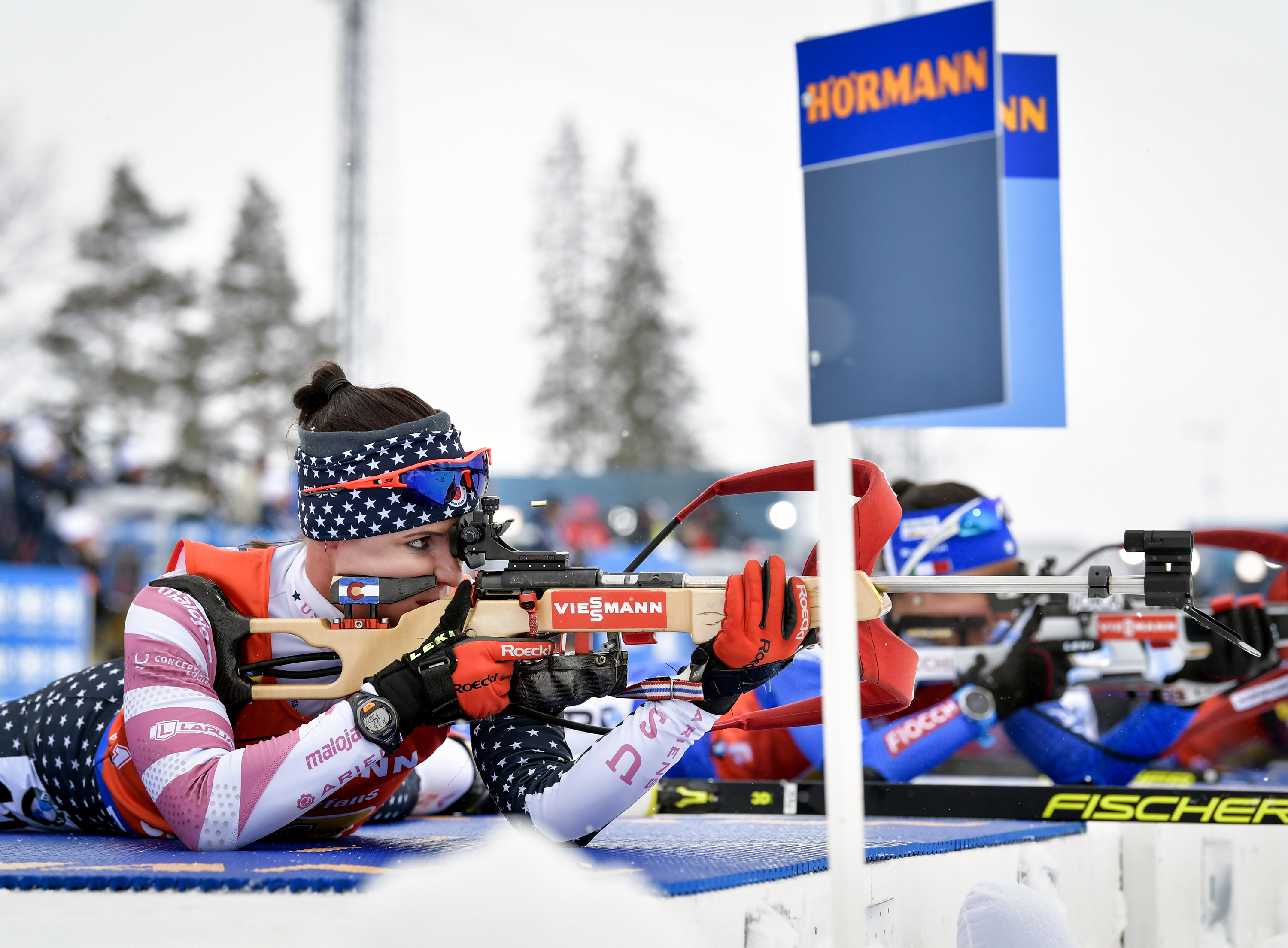 FILE - Joanne Reid, left, of the United States, shoots during the women's 4x6 km relay competition at the IBU World Biathlon Championships in Oestersund, Sweden, March 16, 2019. The U.S. Biathlon board of directors has voted to hire an independent contractor to conduct an audit of “athlete wellness practices and team culture” following an Associated Press story that said Reid had been sexually harassed and abused for years while racing on the elite World Cup circuit.