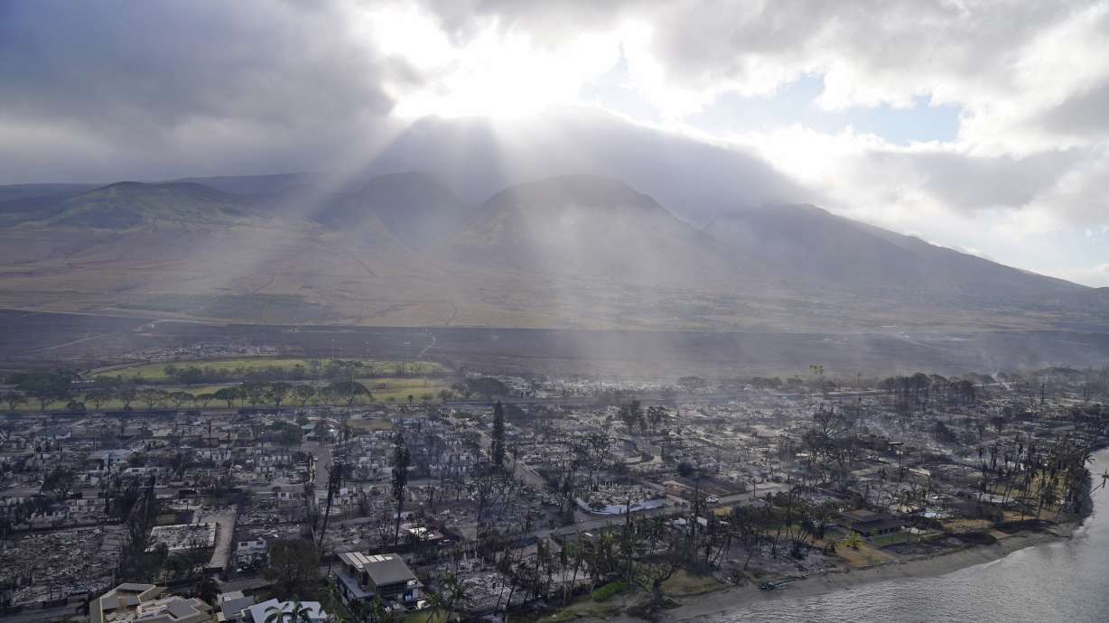 Rays of sunlight pierce through the clouds, Aug. 10, 2023, above homes burned by wildfires in Lahaina, Hawaii. Better communications and equipment are among the recommendations being made by the Maui Police Department in a report released Tuesday.