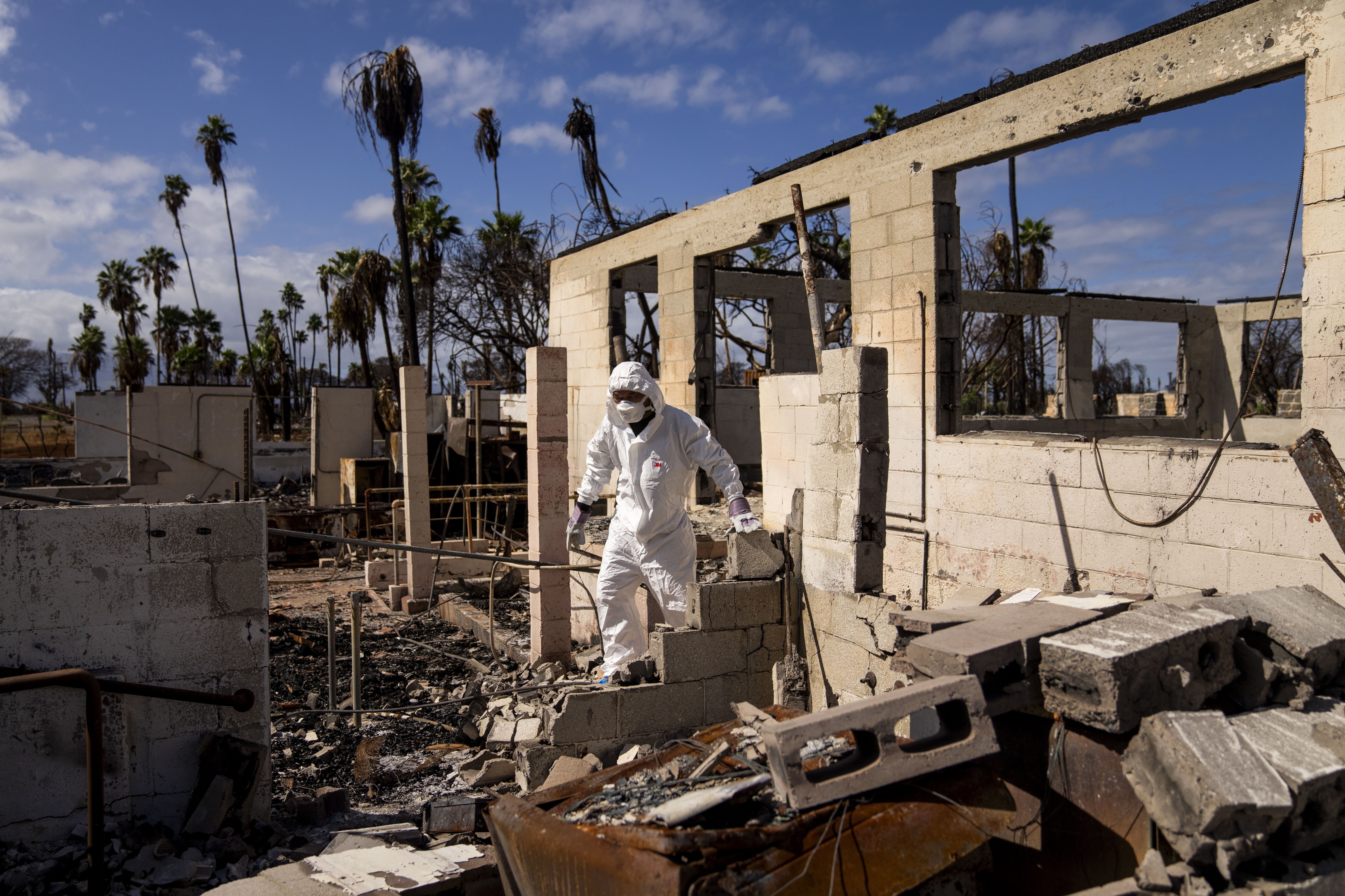 The Rev. Ai Hironaka, resident minister of the Lahaina Hongwanji Mission, walks through the grounds of his temple and residence destroyed by wildfire, Dec. 7, 2023, in Lahaina, Hawaii. Nearly six months after a wind-whipped wildfire destroyed the historic town of Lahaina, the Maui Police Department said Monday it is releasing a preliminary report about its response to the tragedy.