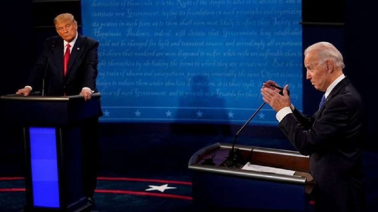 Joe Biden answers a question as Donald Trump listens during the second and final presidential debate in Nashville, Tenn., October 22, 2020. Trump on Monday said he wanted to debate Biden immediately.