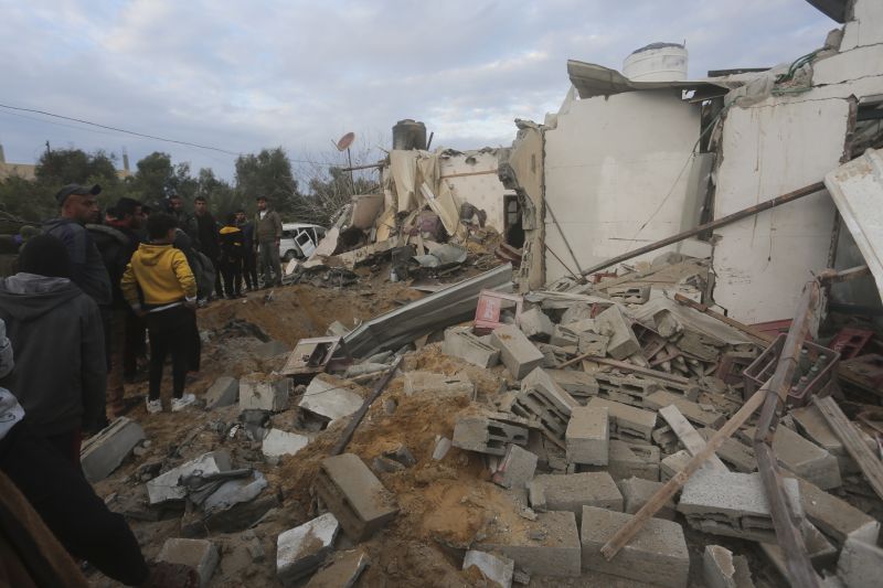 Palestinians look at a residential house destroyed in an Israeli strike in Rafah, Gaza Strip, Monday.