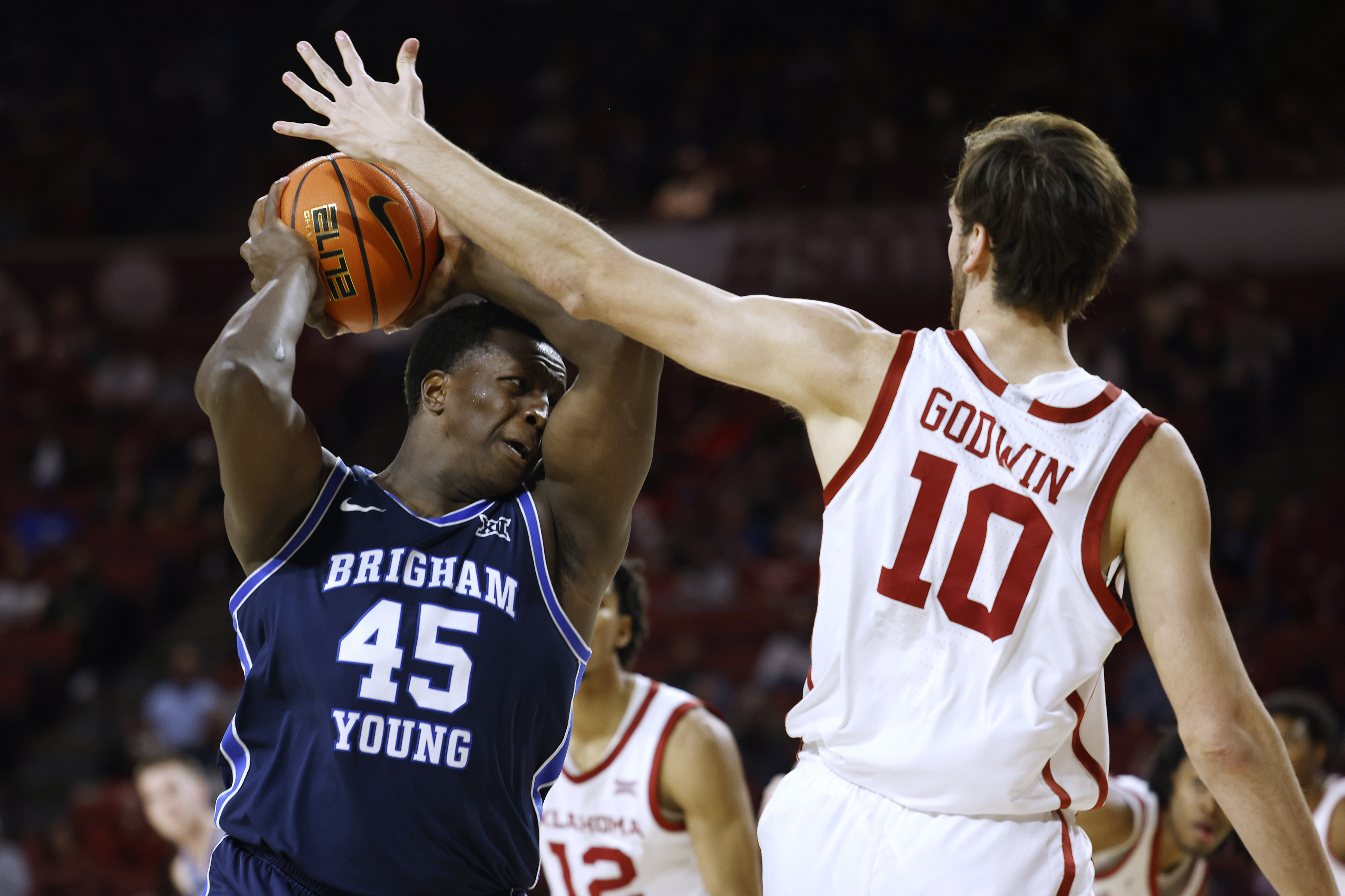 BYU forward Fousseyni Traore (45) is defended by Oklahoma forward Sam Godwin (10) during the first half of an NCAA college basketball game Tuesday, Feb. 6, 2024, in Norman, Okla.