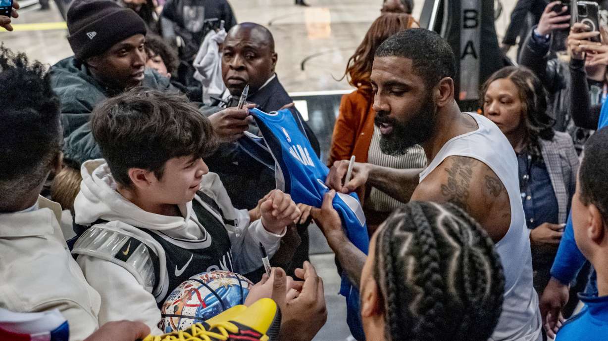 Dallas Mavericks guard Kyrie Irving signs autographs after the team's NBA basketball game against the Brooklyn Nets in New York, Tuesday, Feb. 6, 2024.