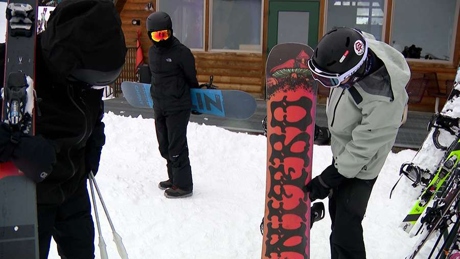 Charlie Duffy shows the snowboard he used to fend off a mountain lion Sunday on Beaver Mountain.