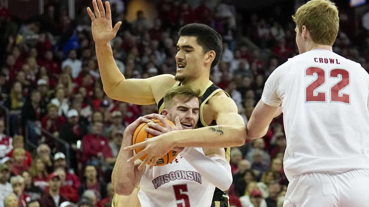 Wisconsin's Tyler Wahl (5) grabs a loose ball away from Purdue's Zach Edey (15) during the first half of an NCAA college basketball game Sunday, Feb. 4, 2024, in Madison, Wis.