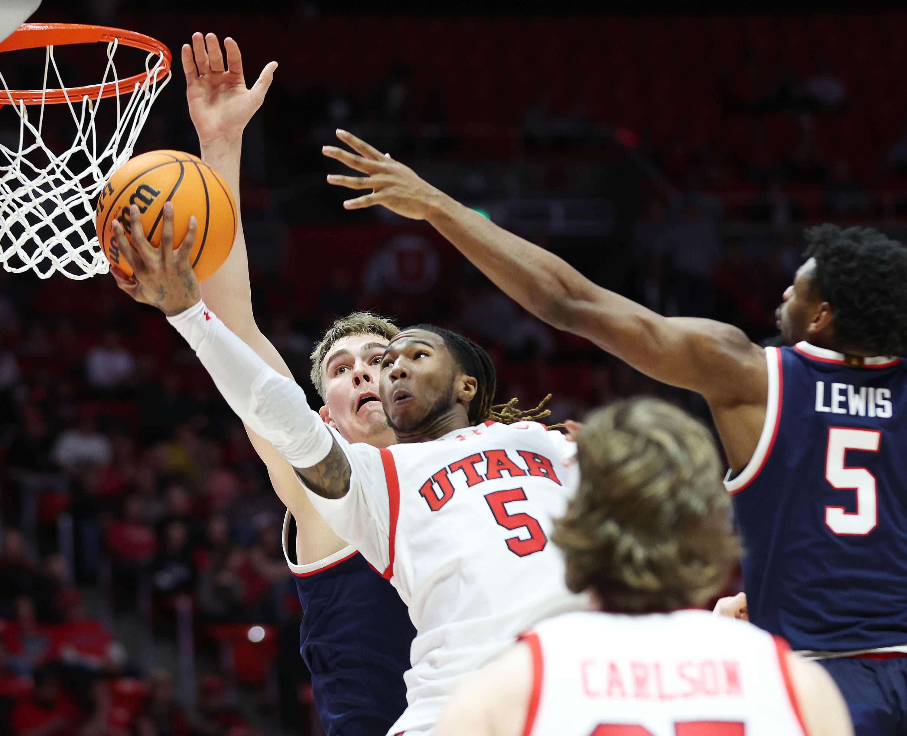 Utah Utes guard Deivon Smith (5) tries to shoot over Arizona Wildcats guard KJ Lewis (5) in Salt Lake City on Thursday, Feb. 8, 2024.