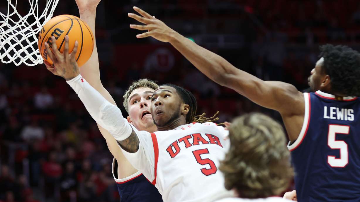 Utah Utes guard Deivon Smith (5) tries to shoot over Arizona Wildcats guard KJ Lewis (5) in Salt Lake City on Thursday, Feb. 8, 2024.