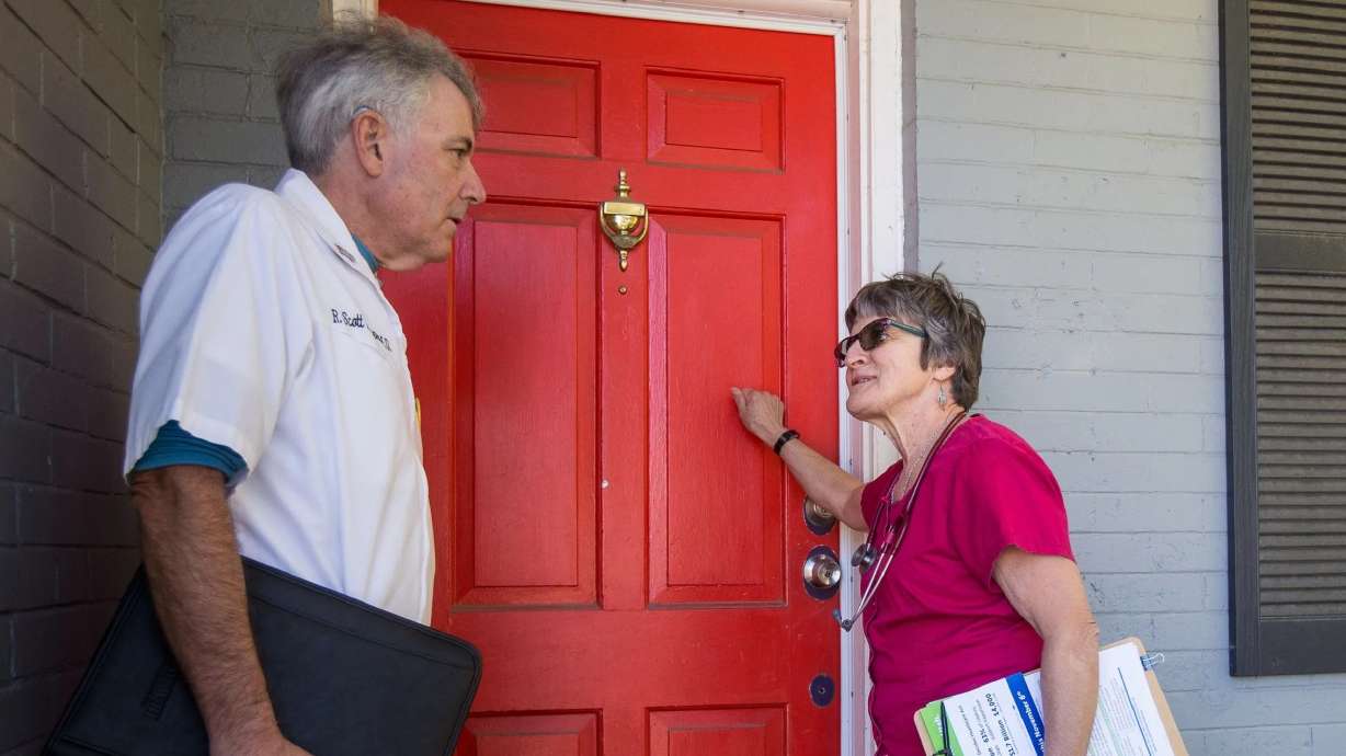 Shirley Belleville and Scott Poppen knock on a door to rally support for a ballot initiative in Salt Lake City on Oct. 13, 2018.