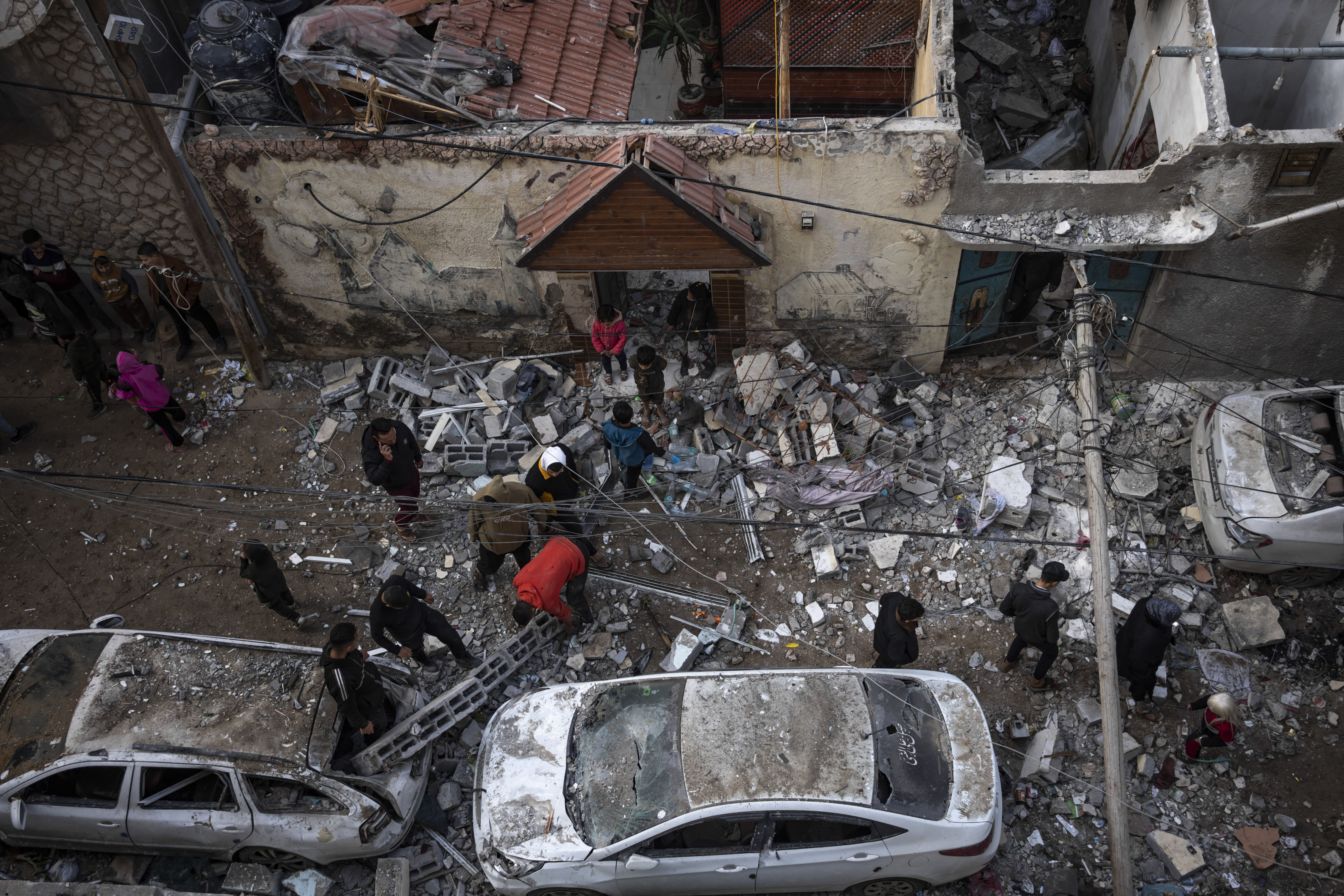 Palestinians look at the destruction after an Israeli airstrike in Rafah, Gaza Strip, Friday.